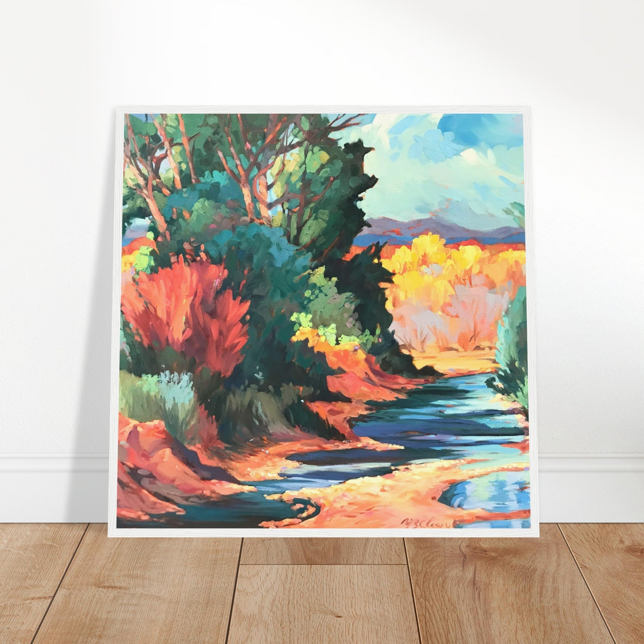 Colorful landscape painting of a forest and stream on a white wall.