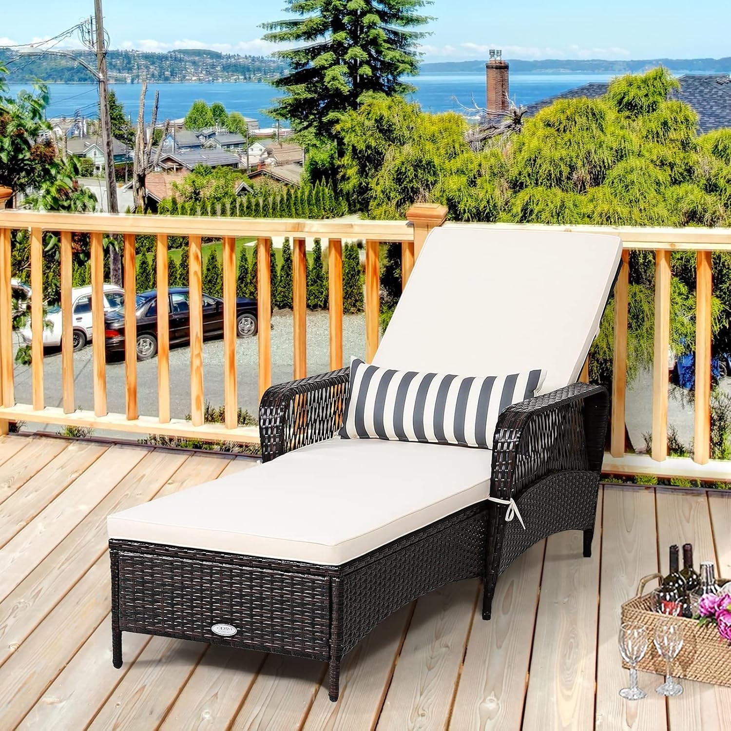 Outdoor lounge chair with striped pillow on a wooden deck overlooking a scenic view.