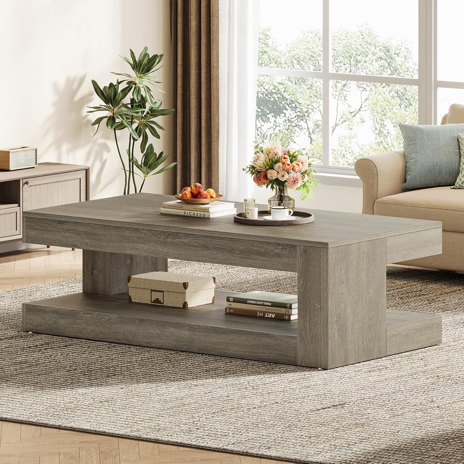 Gray coffee table in a living room with decor items and a couch.