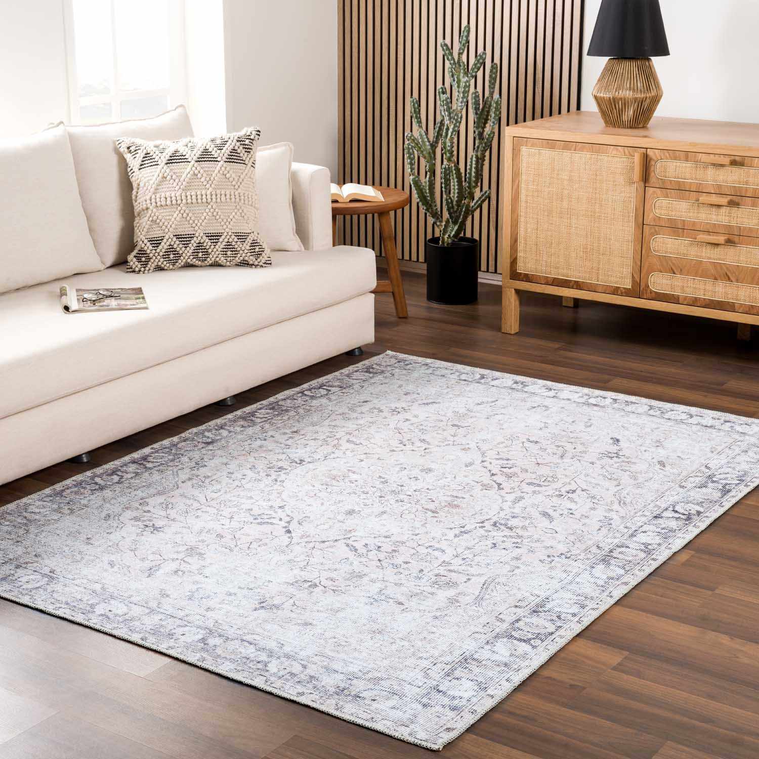Living room with a beige sofa, decorative pillow, wooden sideboard, and patterned rug.