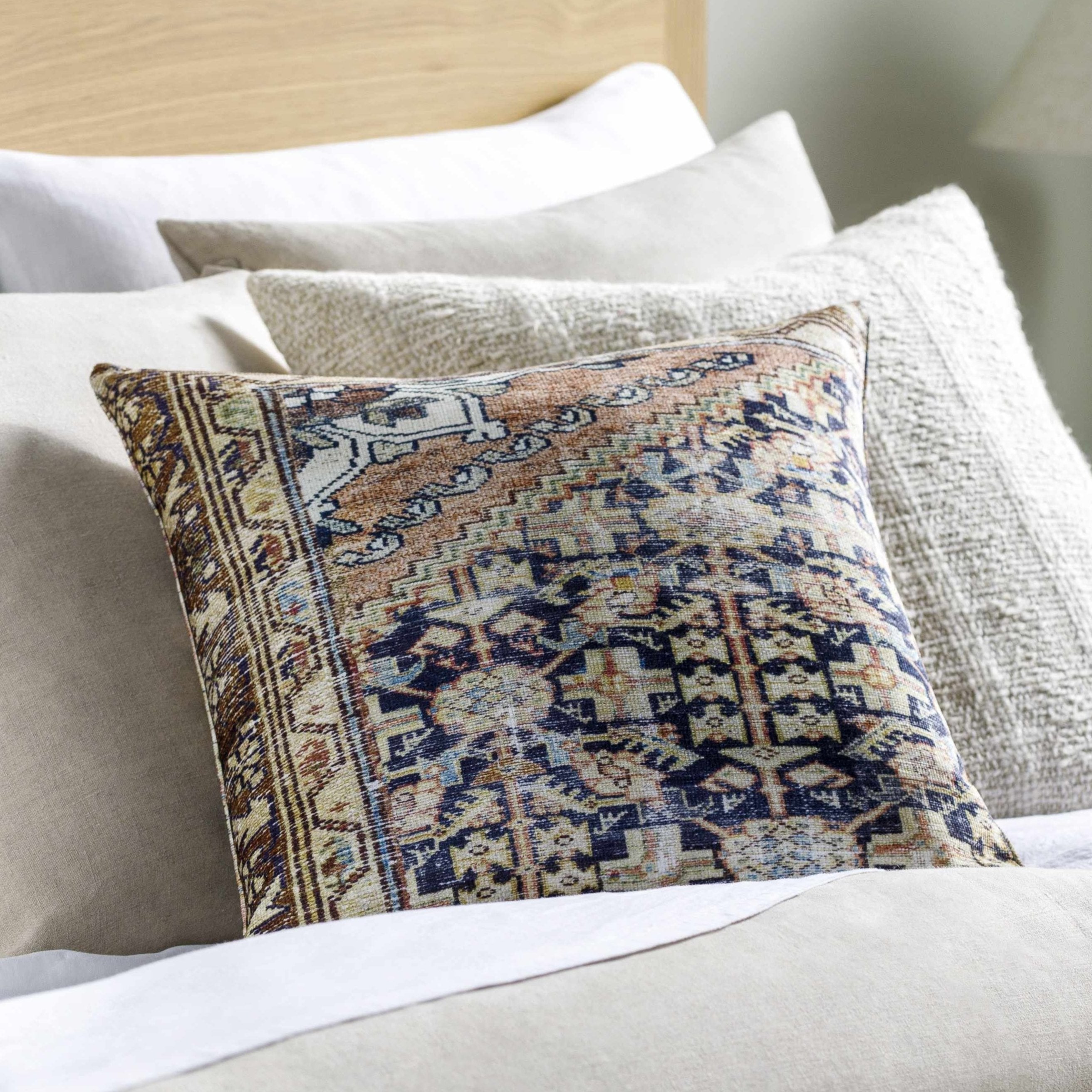 Decorative pillow with intricate pattern on a bed