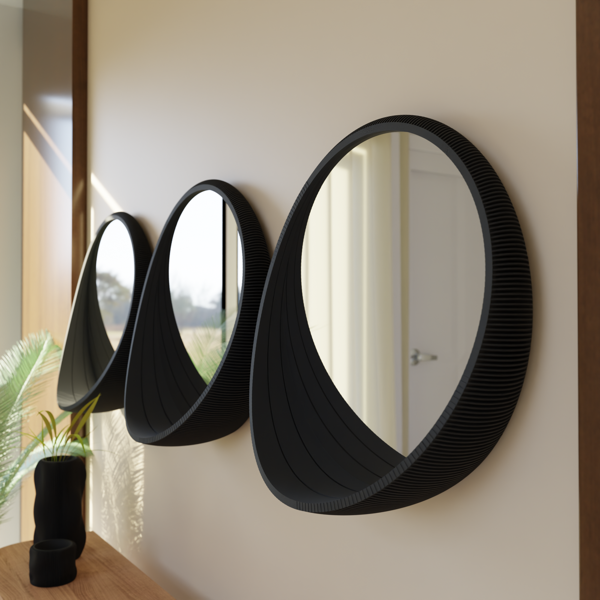 Three black circular mirrors on a wall with a plant in the corner.