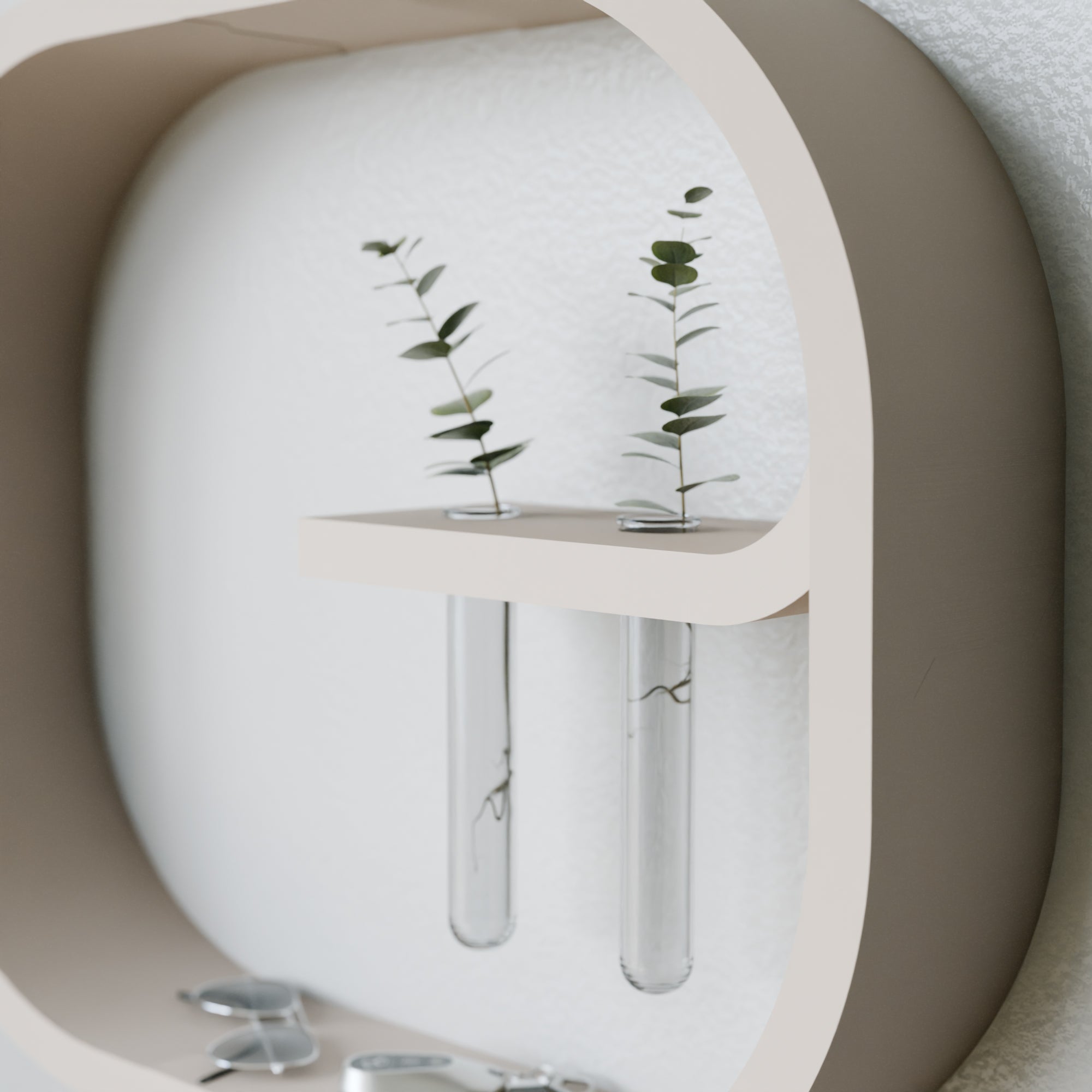 Decorative wall shelf with test tube vases and eucalyptus leaves on a neutral background