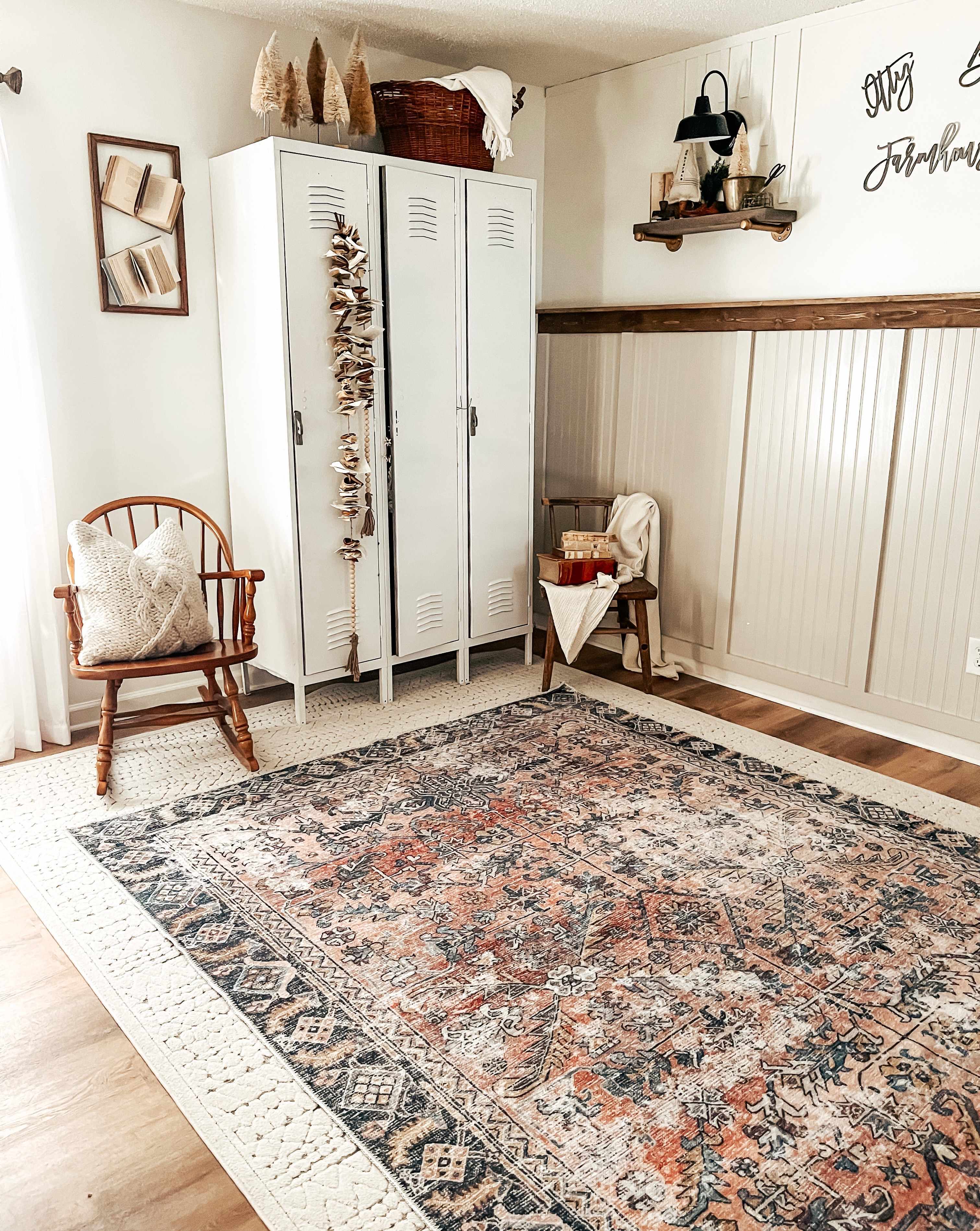 Mudroom with patterned rug, wooden chair, and white lockers.