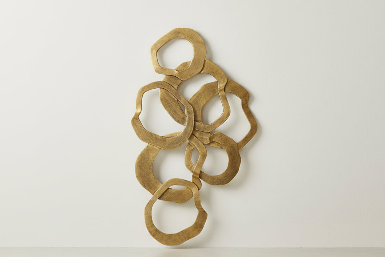 Decorative wall art with interlocking gold circular shapes on a white background