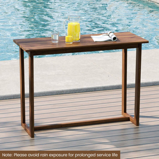 Wooden table with drinks and a magazine by a poolside