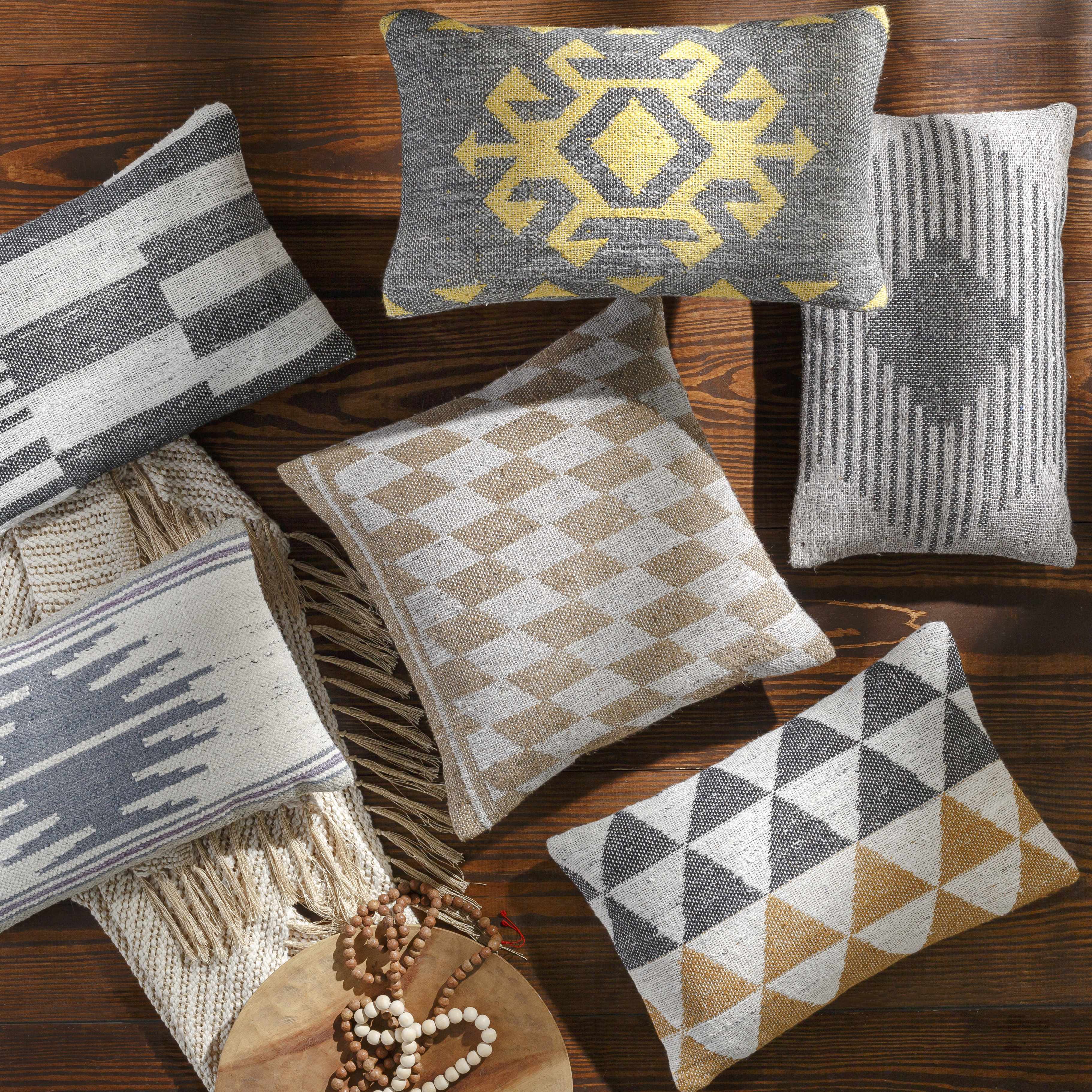 Collection of patterned pillows on a wooden surface