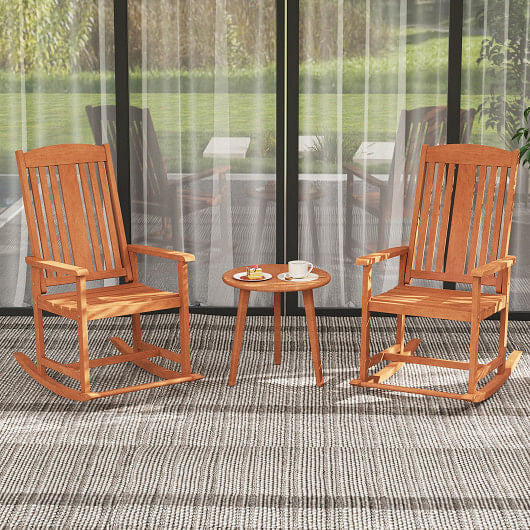 Two wooden rocking chairs with a small table on a patio