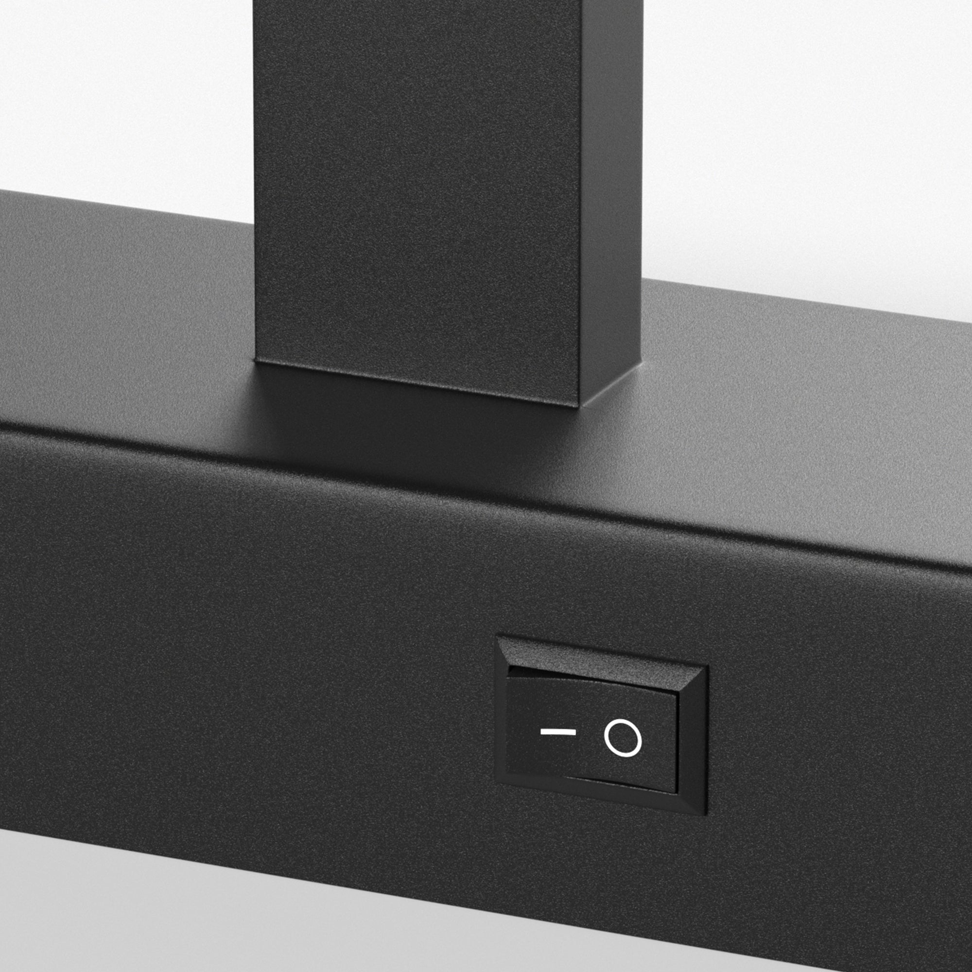 Black kitchen hood with a control switch on a gray surface