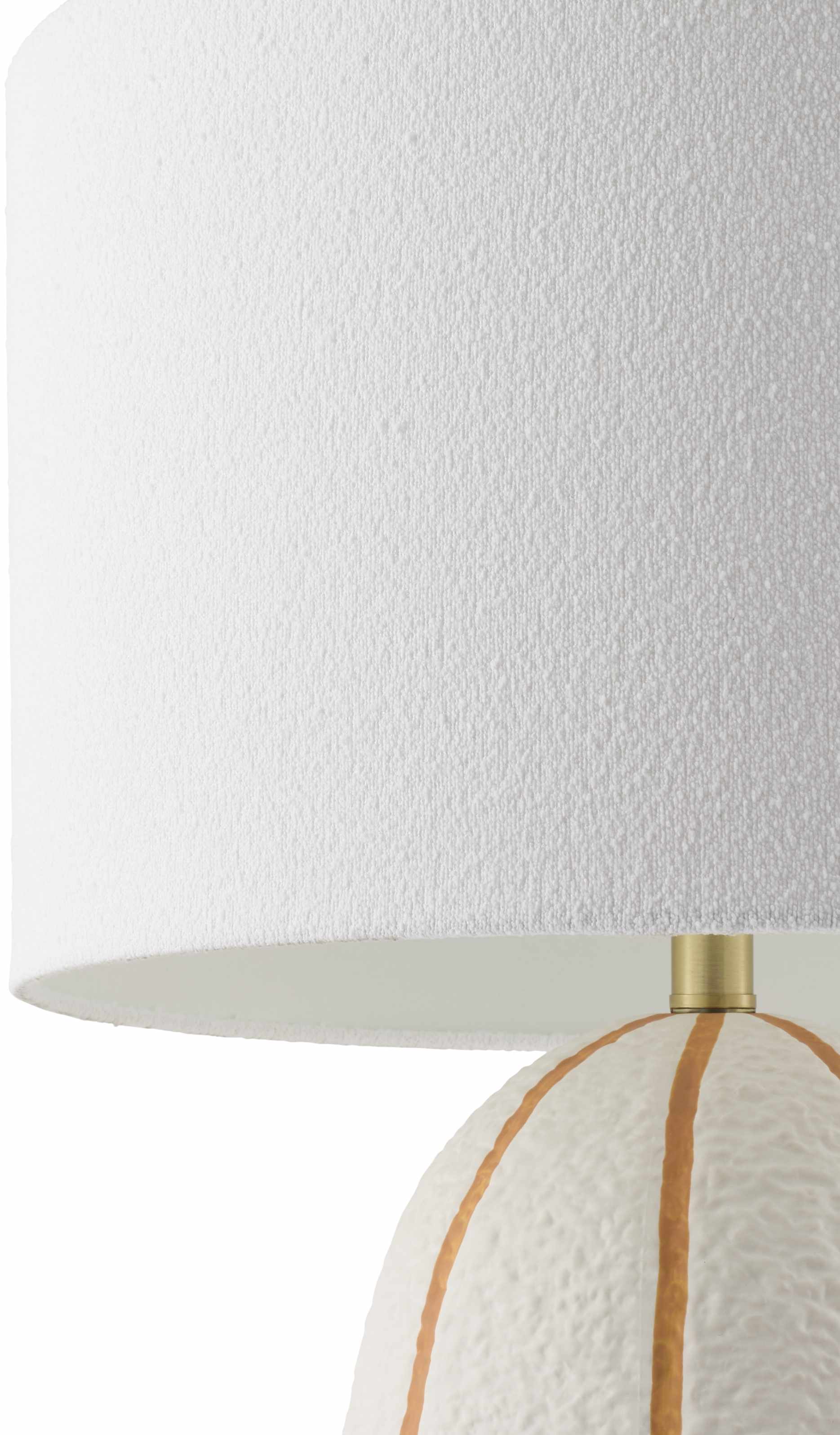 Close-up of a lamp with a white shade and textured base.