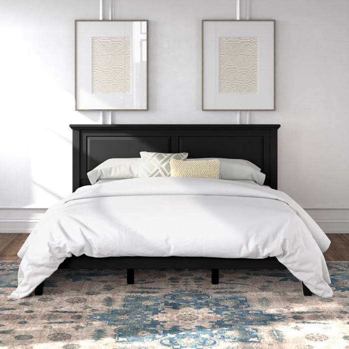 Black bed frame with white bedding in a room with two framed artworks on the wall.