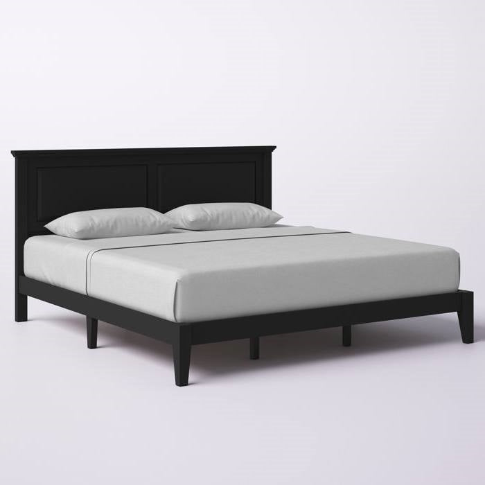 Black bed frame with white mattress and pillows on a light gray background