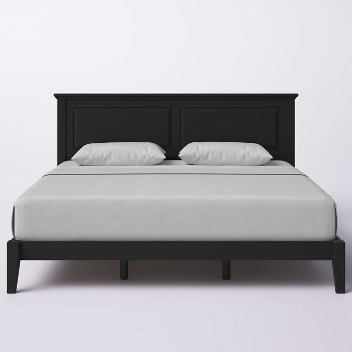 Black bed frame with white mattress and pillows on a light gray background