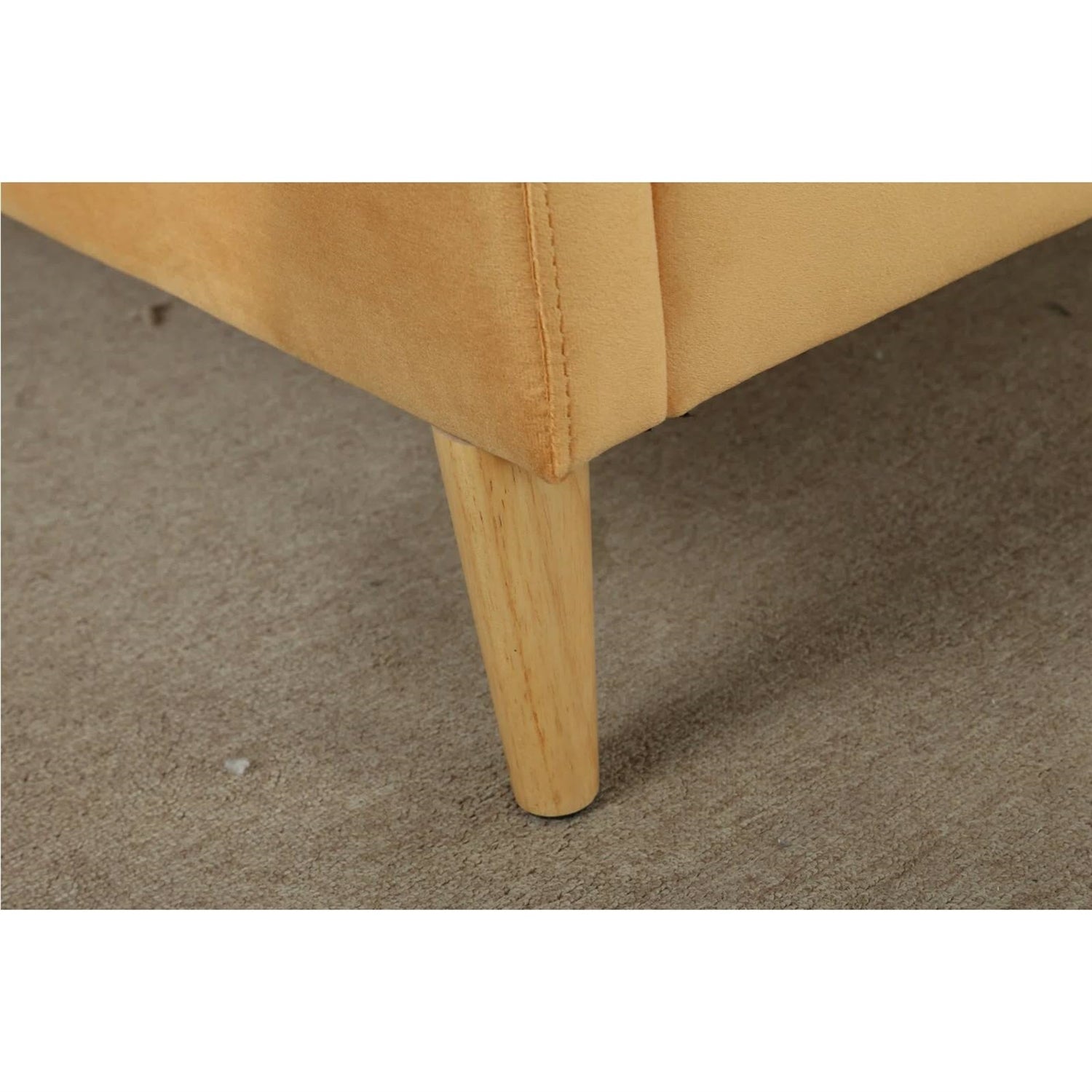 Close-up of a beige upholstered chair leg on a carpeted floor