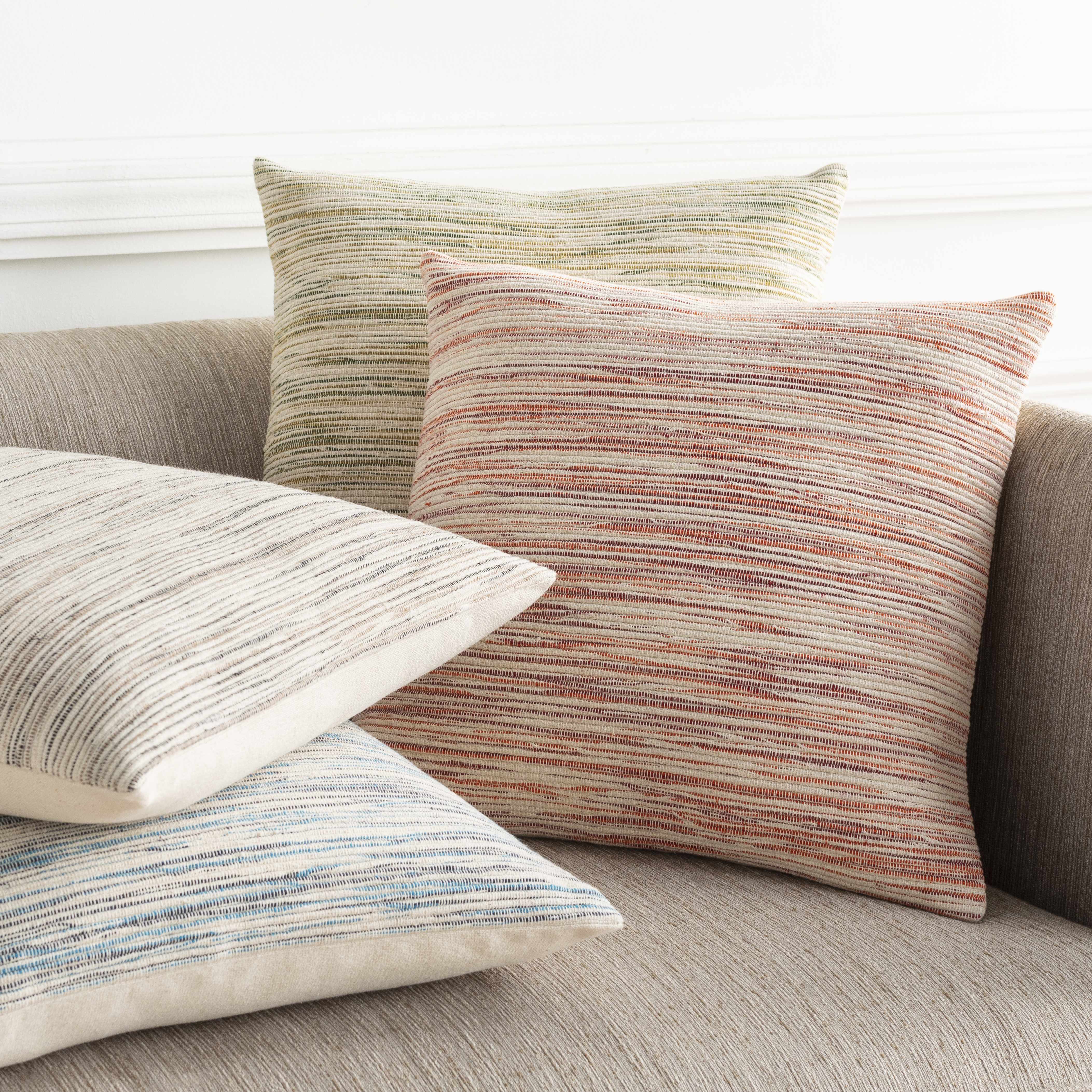 Textured throw pillows on a sofa with a neutral background