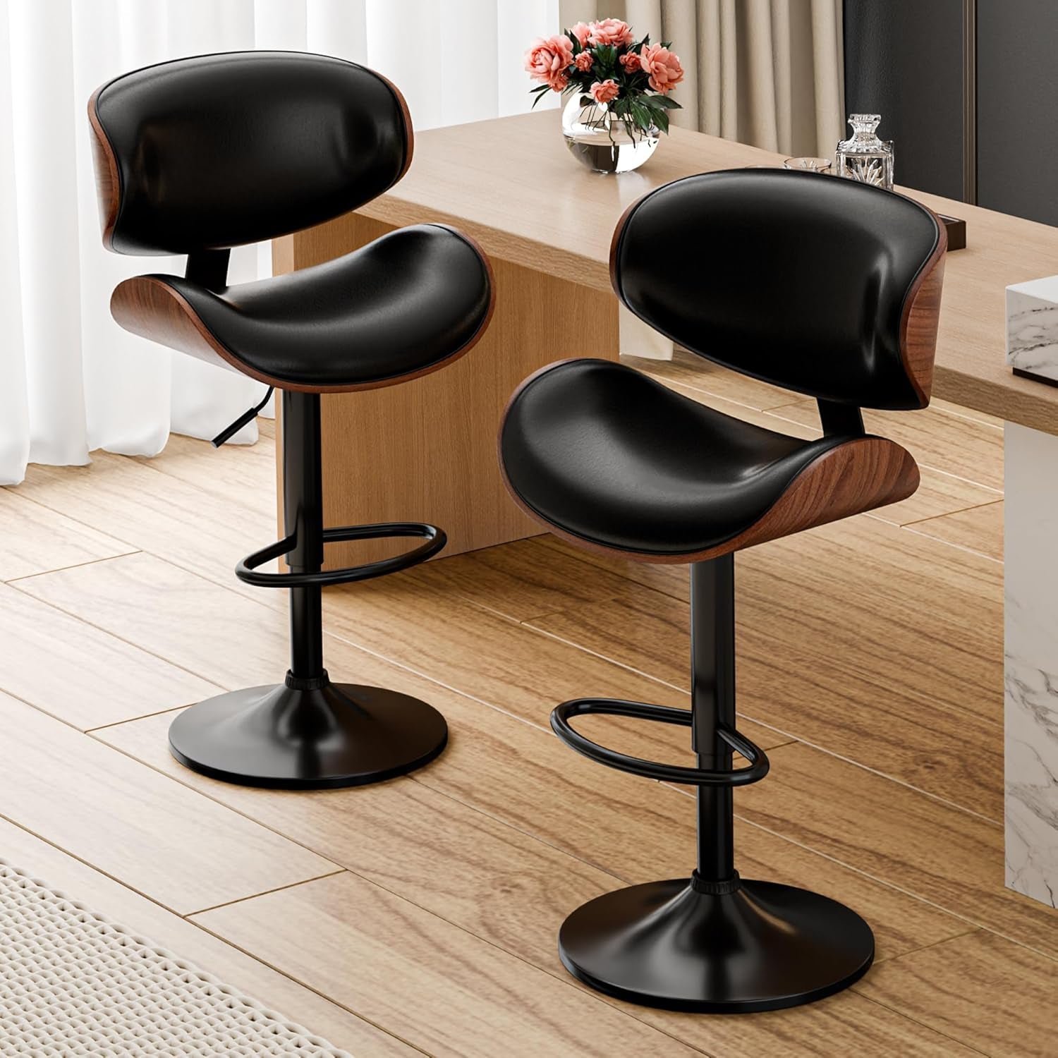 Two black bar stools with wooden seats on a wooden floor.