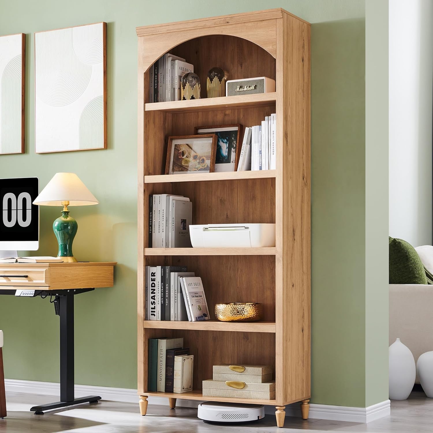 Wooden bookshelf with books and decor against a green wall