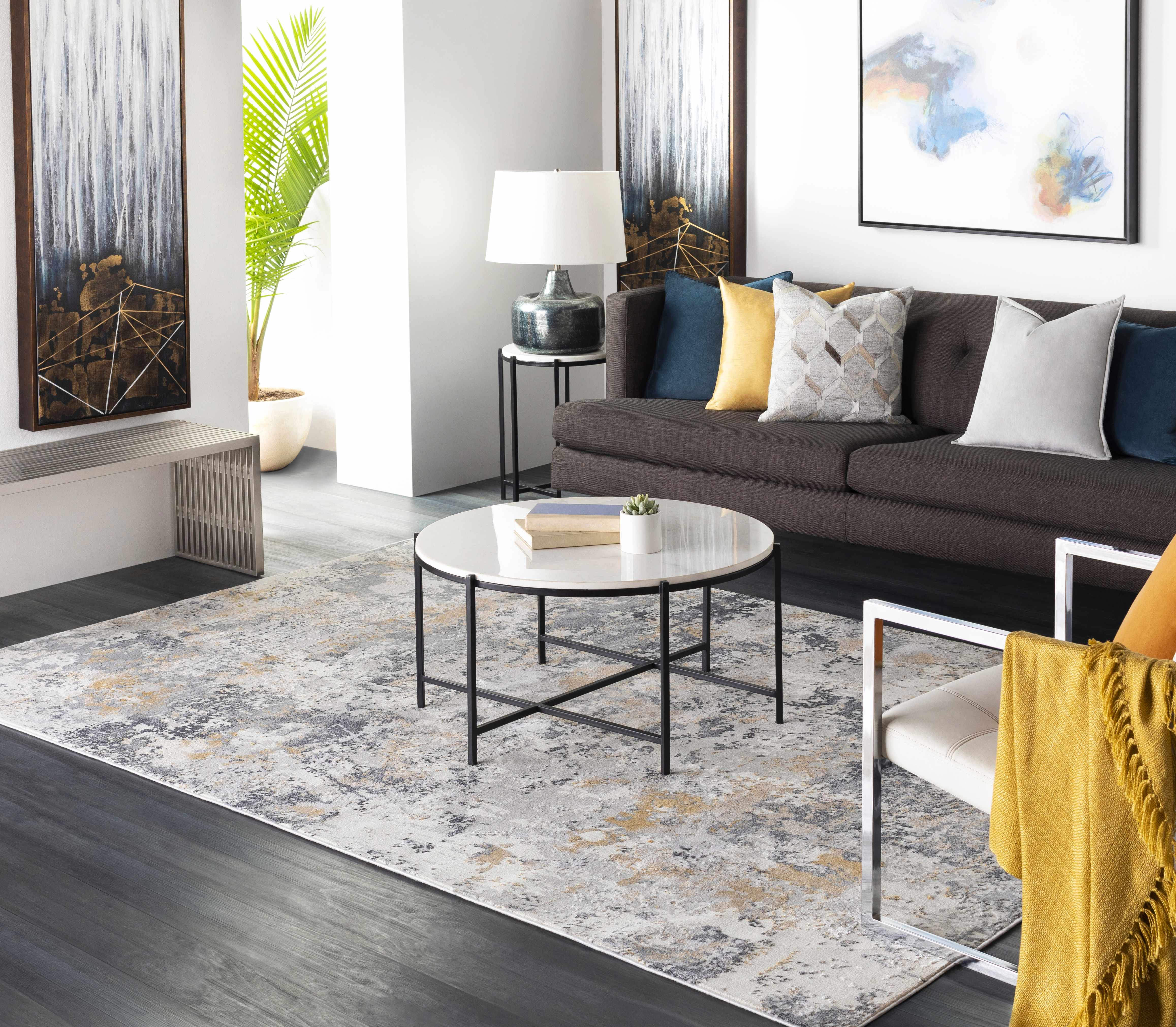 Modern living room with a gray sofa, round coffee table, and abstract art on the walls.