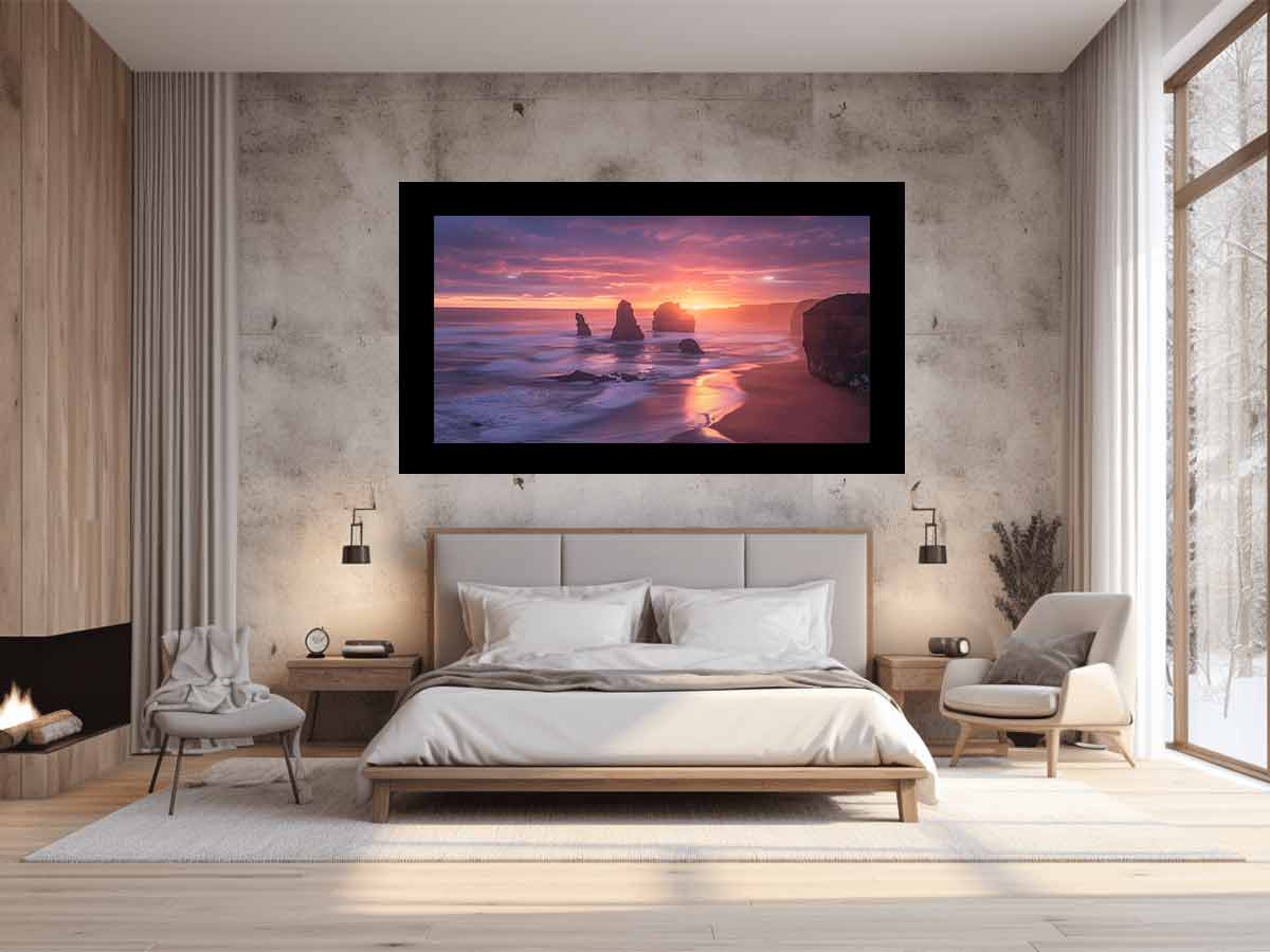 Modern bedroom with a large framed artwork of a sunset over water on the wall.