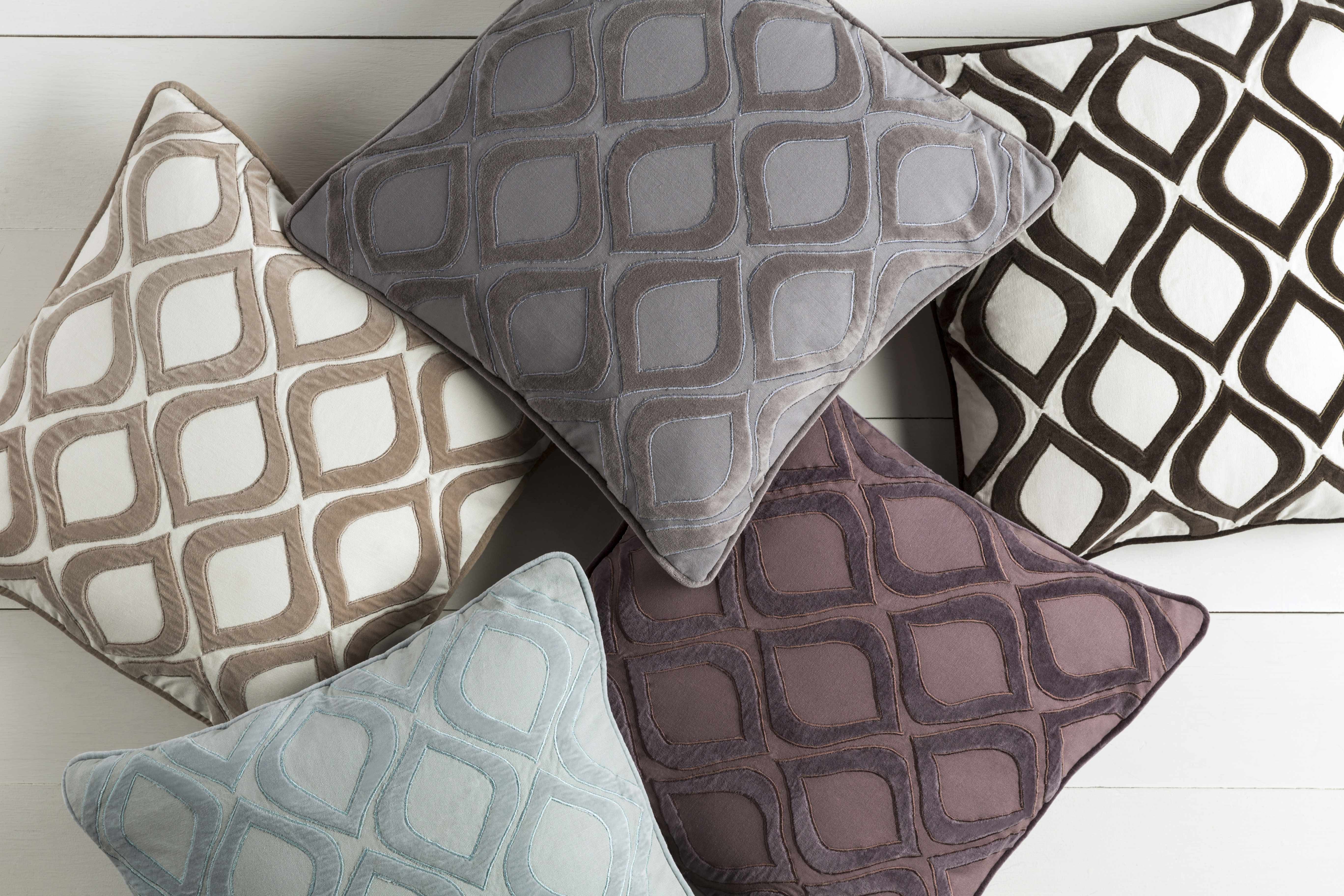 Four patterned cushions on a light wooden surface