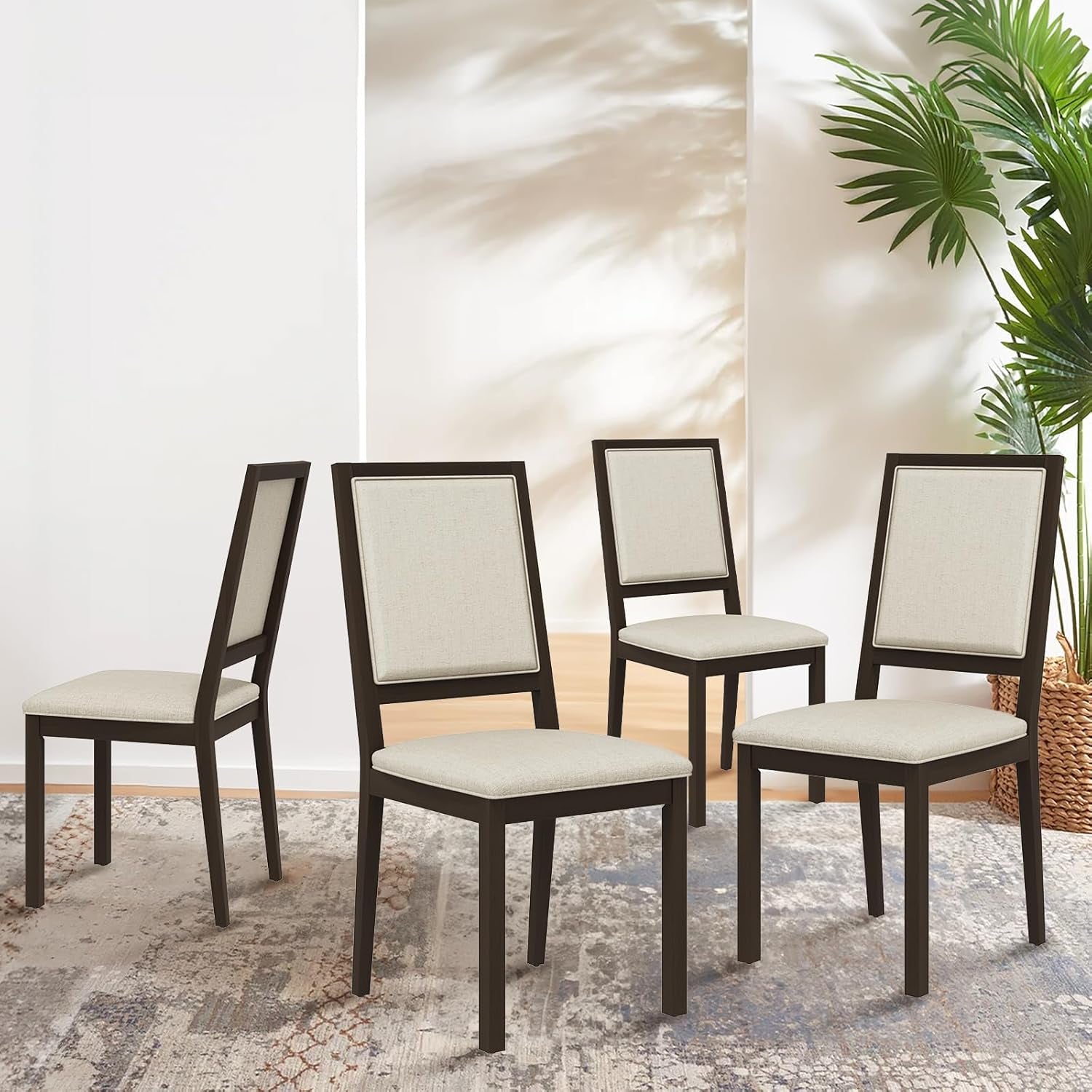 Four dining chairs with white cushioned seats and dark wooden frames on a textured rug.