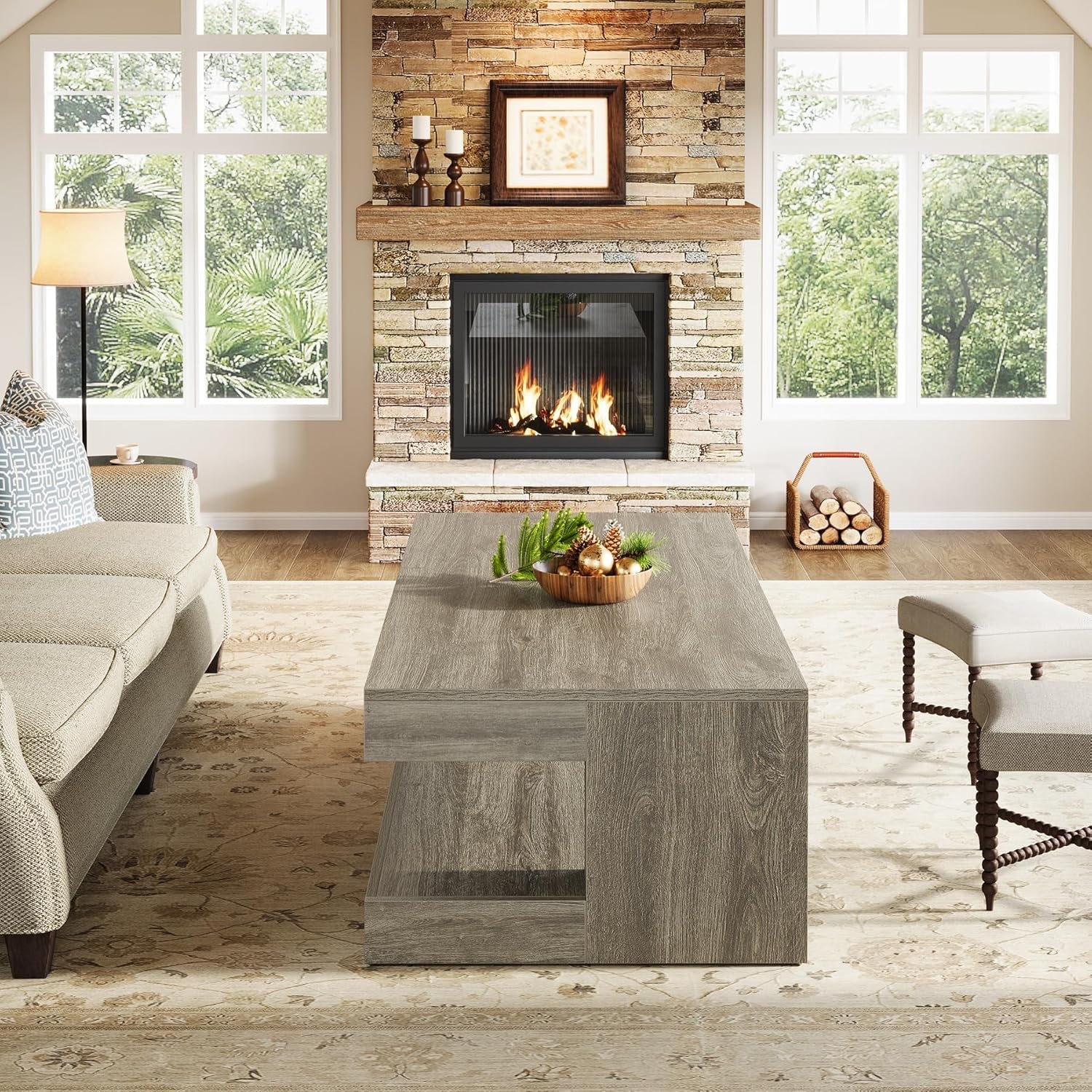 Living room with a stone fireplace, coffee table, and decorative items.