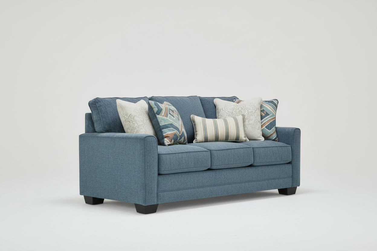 Blue sofa with patterned cushions on a white background