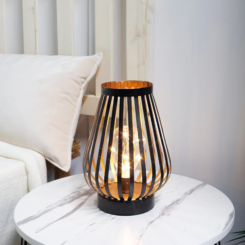 Decorative table lamp with a black and gold striped design on a marble surface.