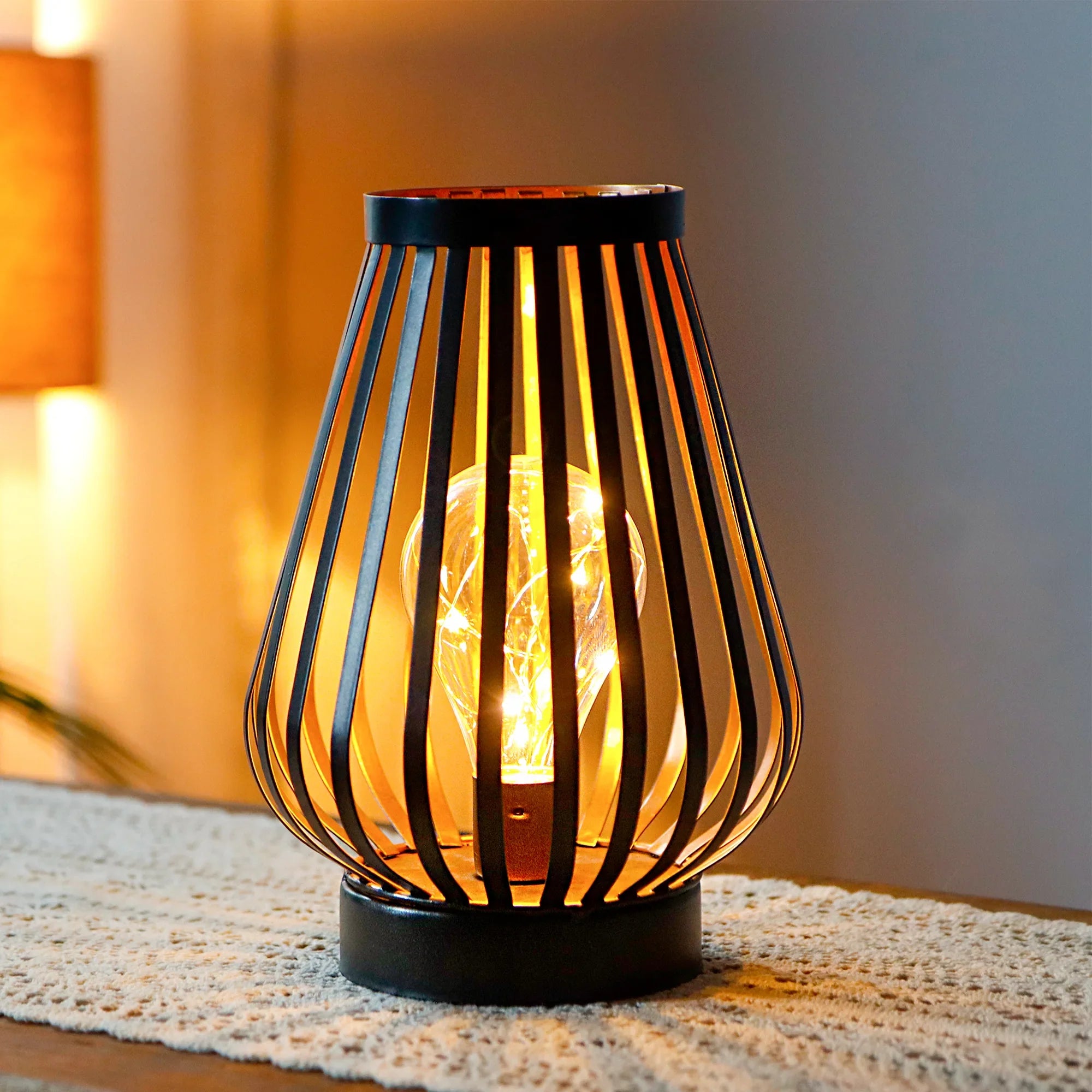 Decorative lamp with wavy metal design on a textured surface