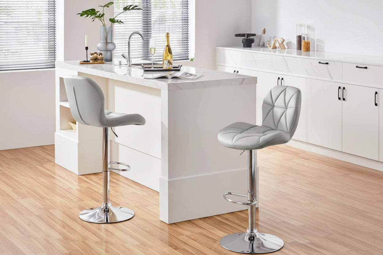 Woman sitting on a gray bar stool in a modern kitchen, drinking champagne.