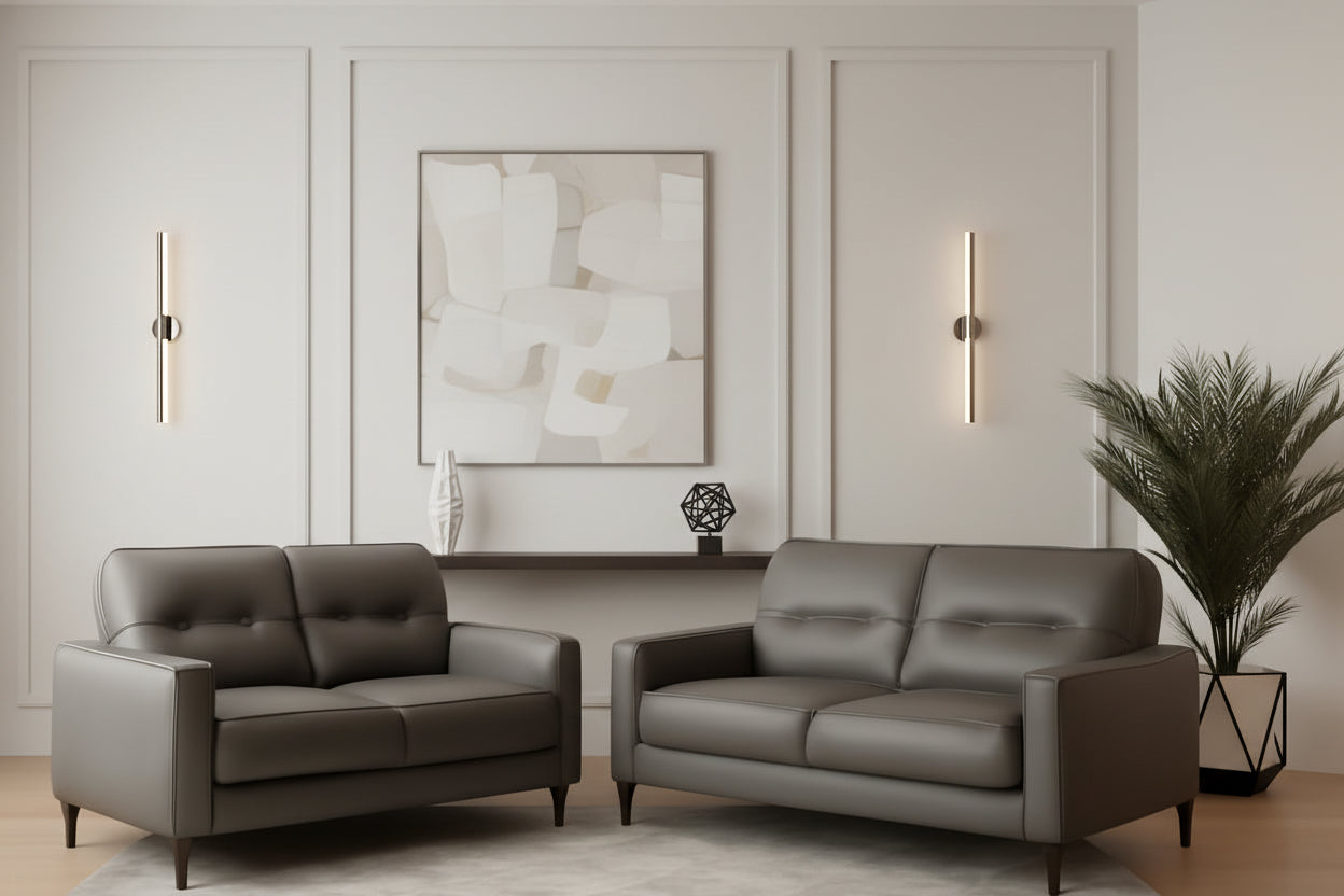 Gray leather sofa set in a living room with a lamp and plant.
