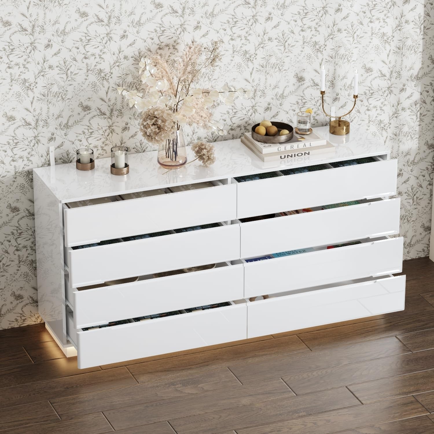 White dresser with decorative items against a patterned wall.