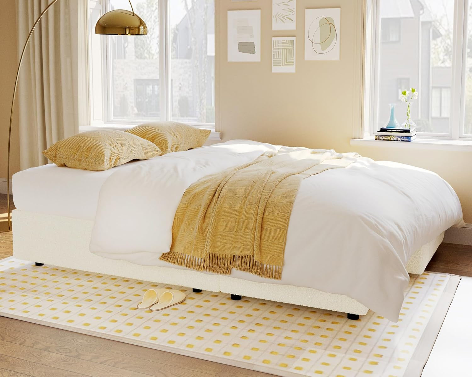 Neatly made bed with white bedding and yellow blanket in a bright bedroom.