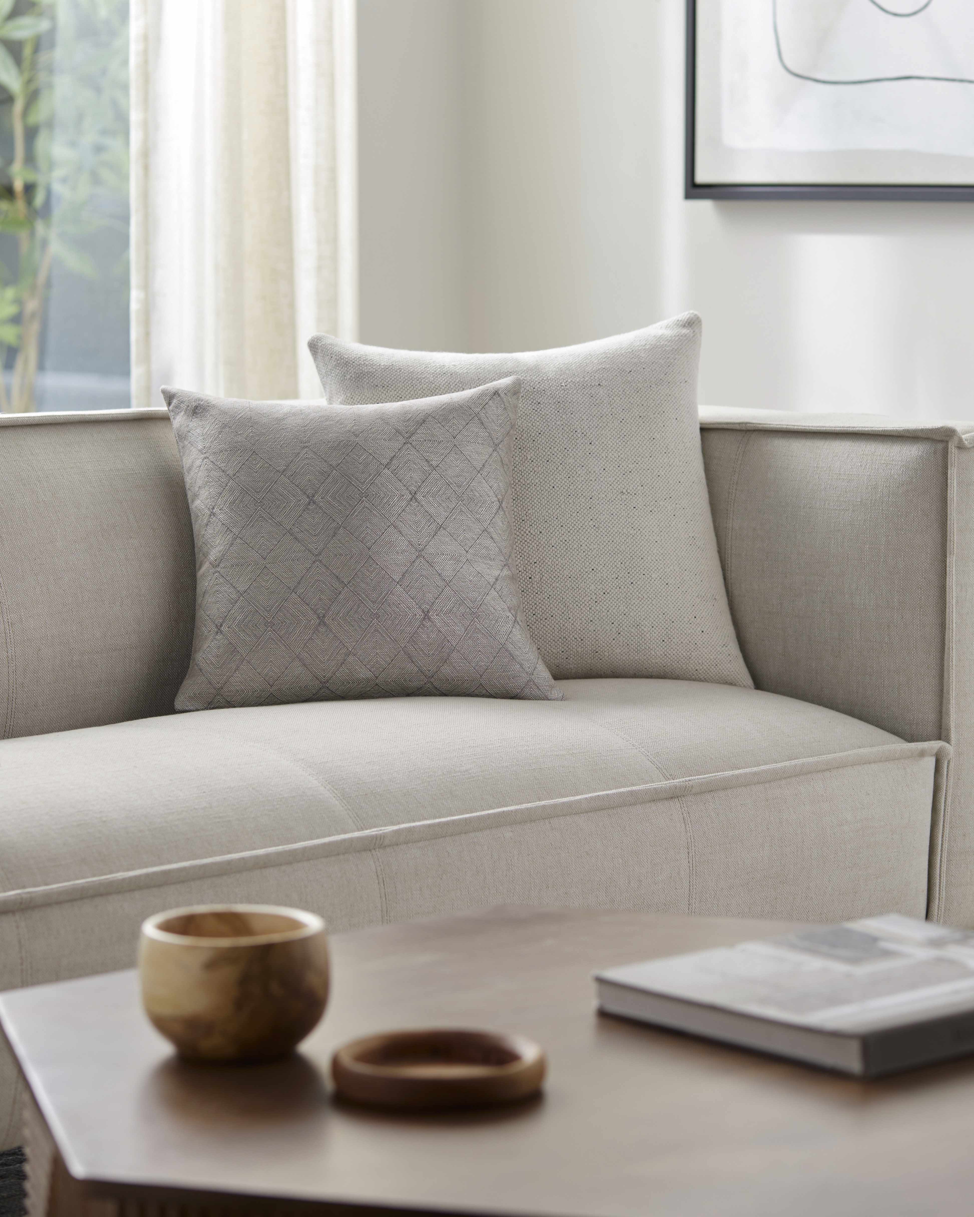 Gray sofa with textured pillows in a living room setting