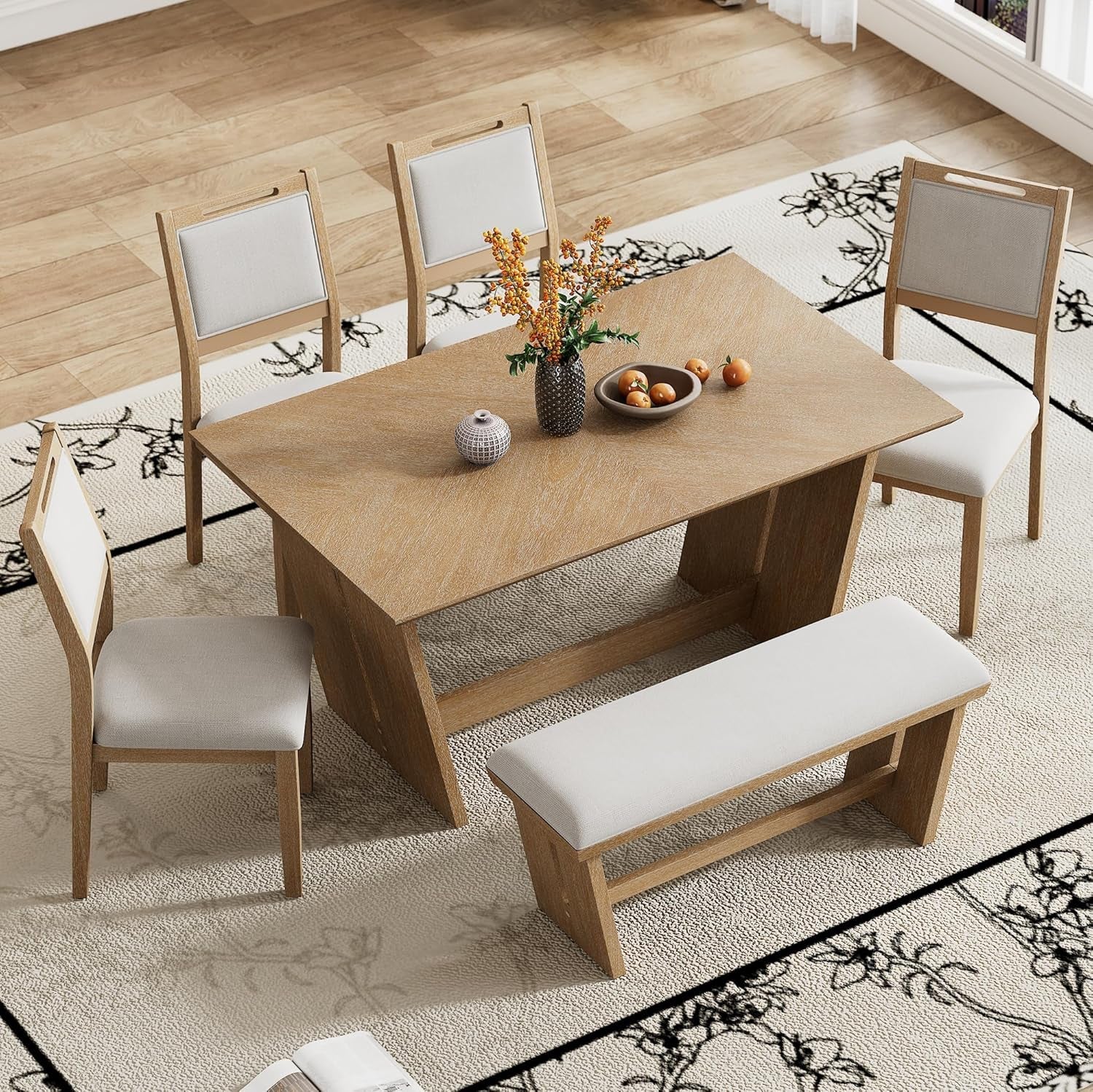 Dining table set with chairs and a bench on a patterned rug.
