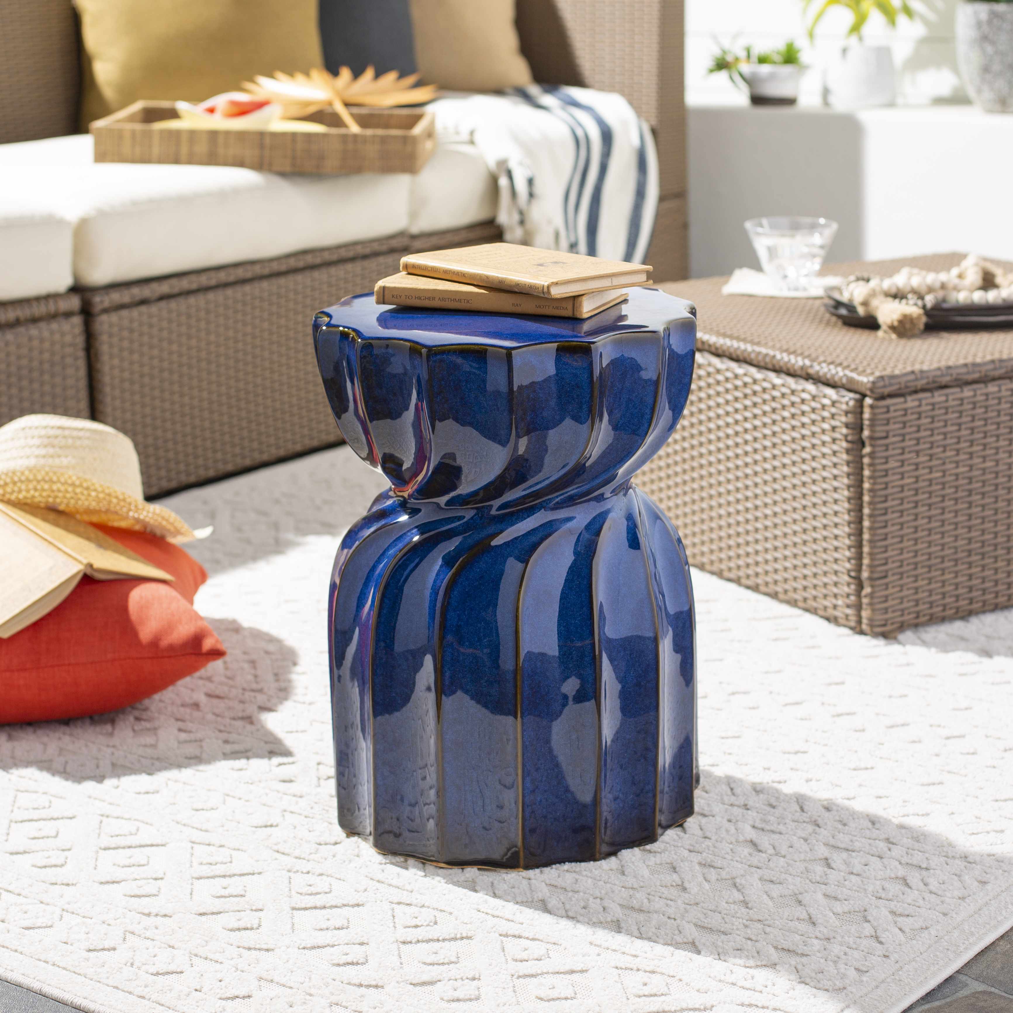 Blue ceramic stool in an outdoor living space with furniture and decor.