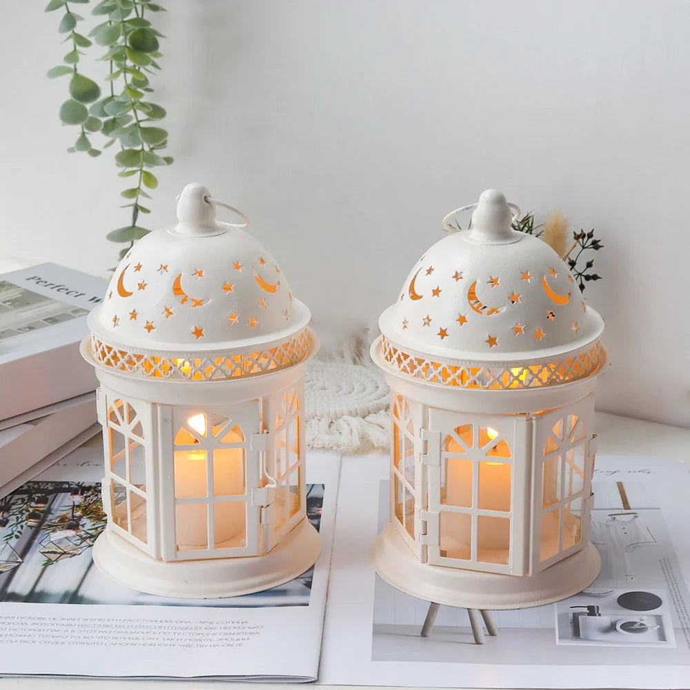 Two white lanterns with decorative cutouts on a magazine