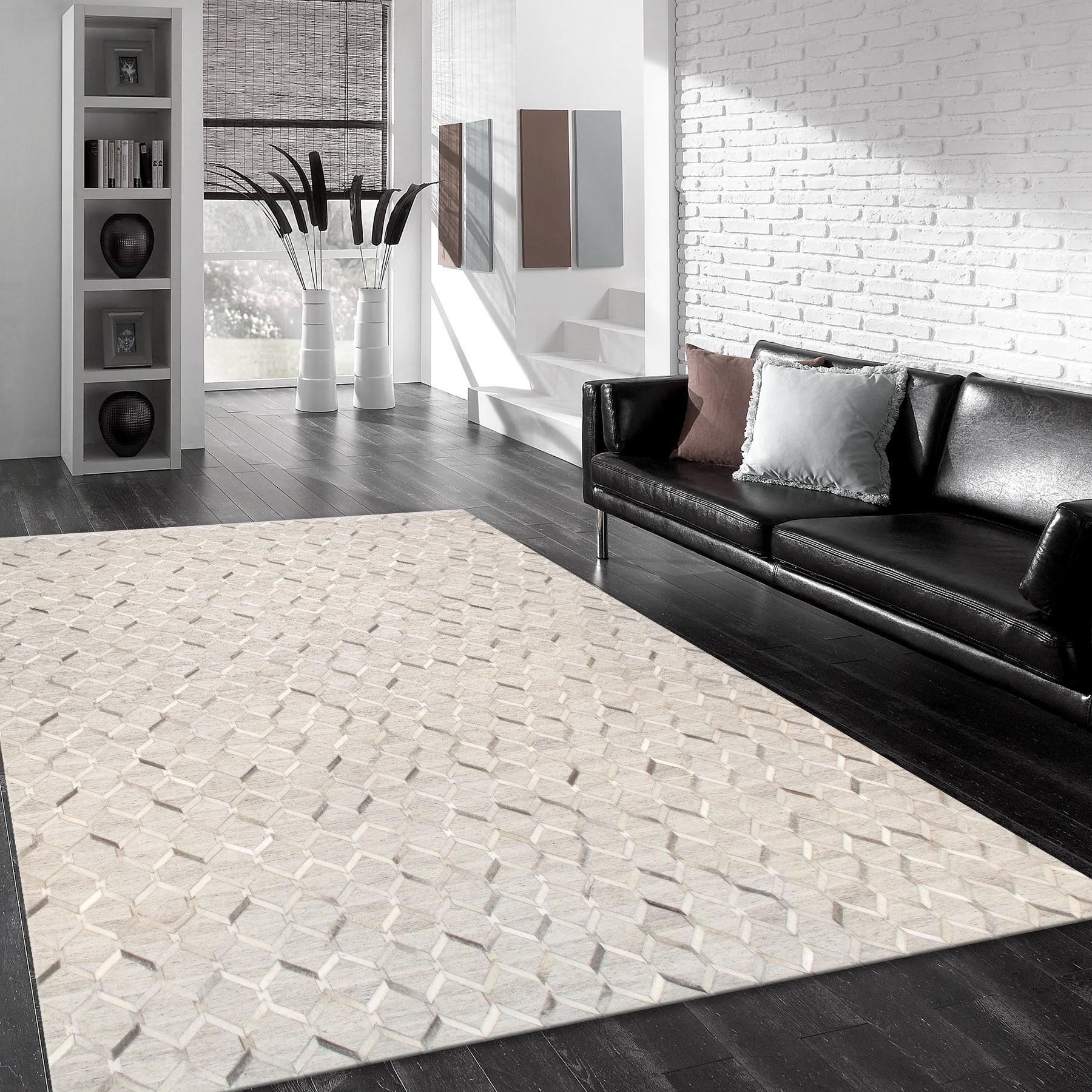 Modern living room with a patterned rug, black sofa, and white brick wall.