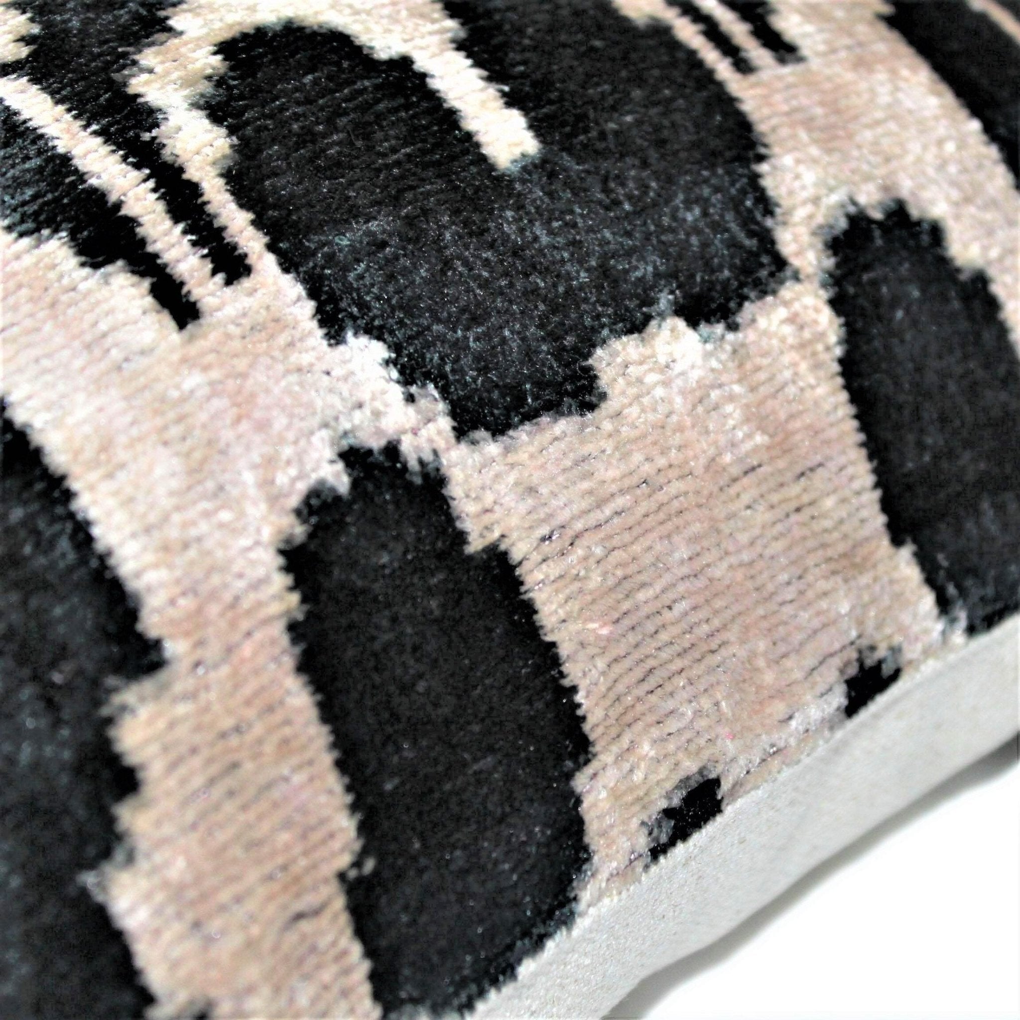 Close-up of a textured rug with black and beige checkered pattern