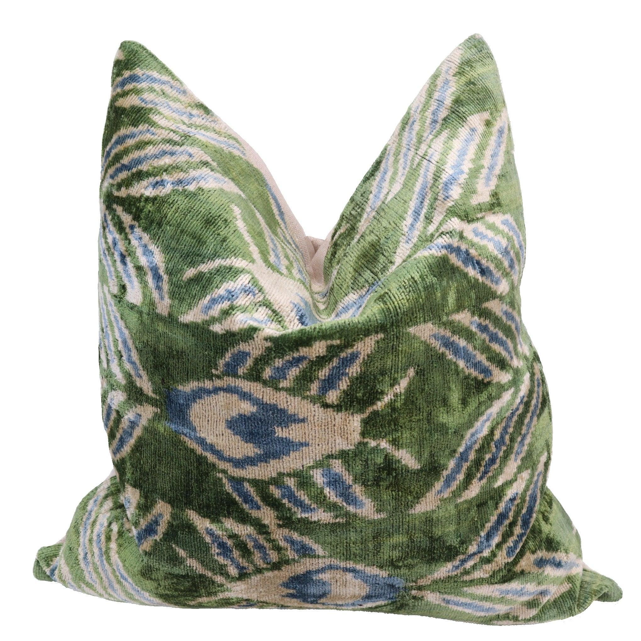 Green patterned pillow with blue and beige accents on a white background