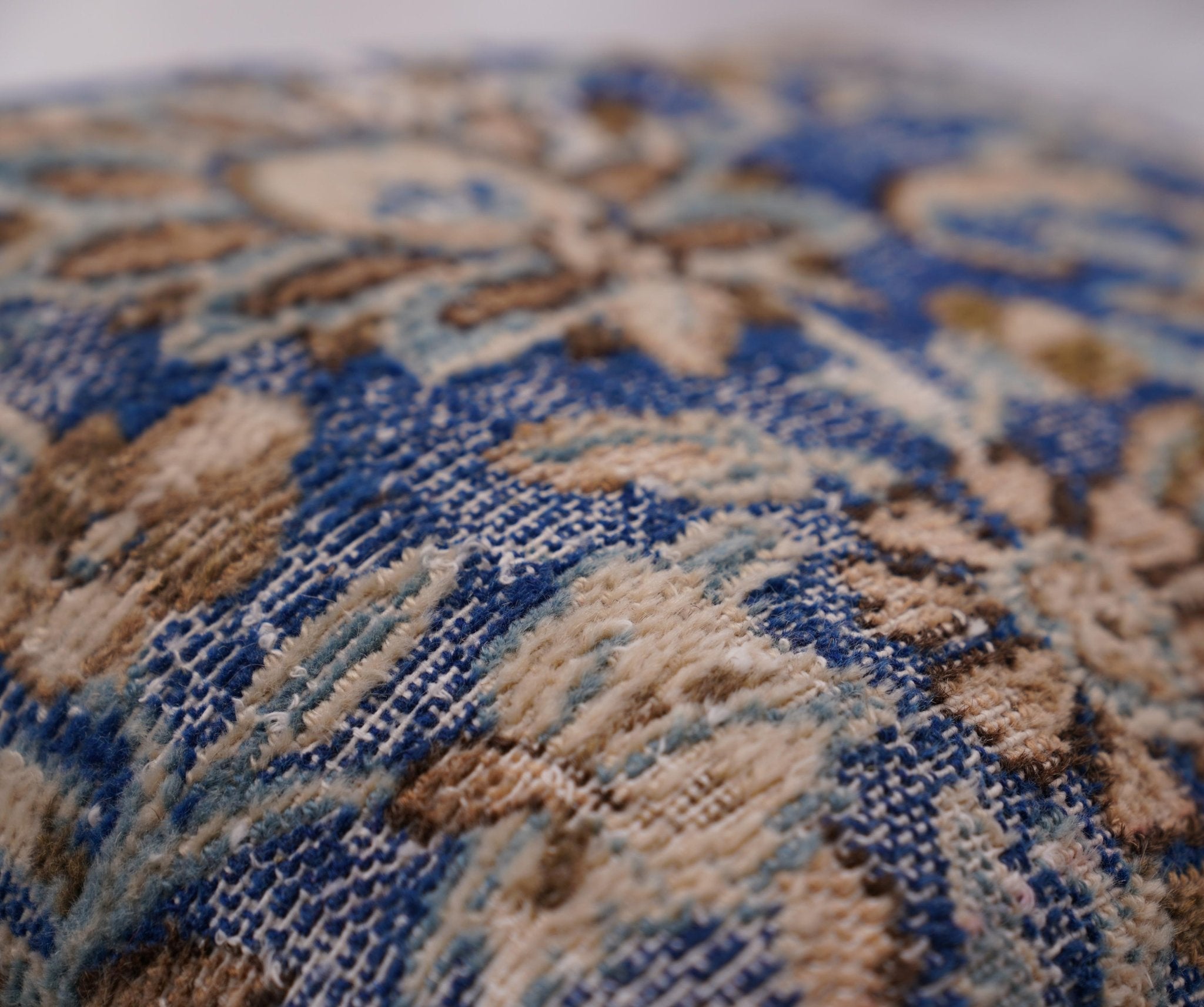 Close-up of a patterned rug with blue and brown colors.