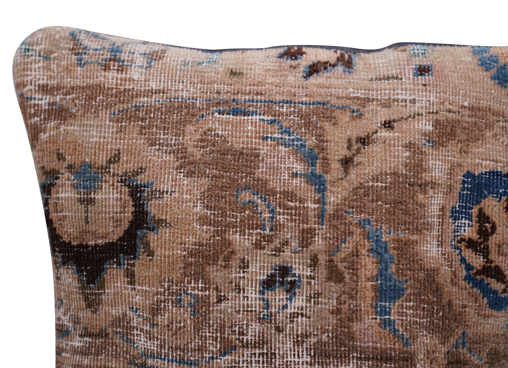Patterned pillow with brown, blue, and black colors on a plain background