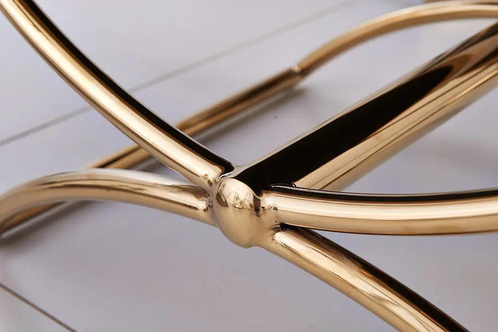 Close-up of a gold metal chair frame on a light wooden floor.