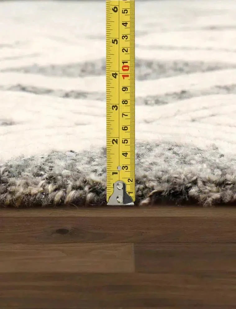 Measurement of a rug on a wooden floor with a tape measure