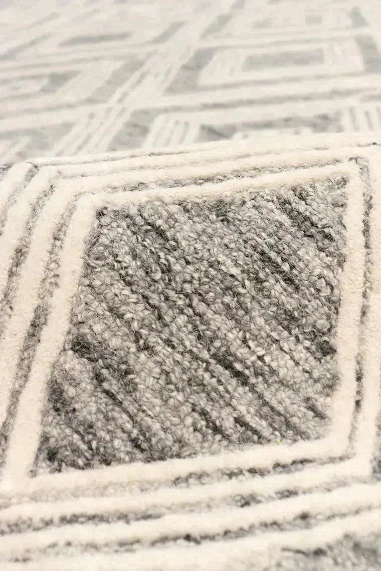 Close-up of a textured gray and white area rug with geometric pattern