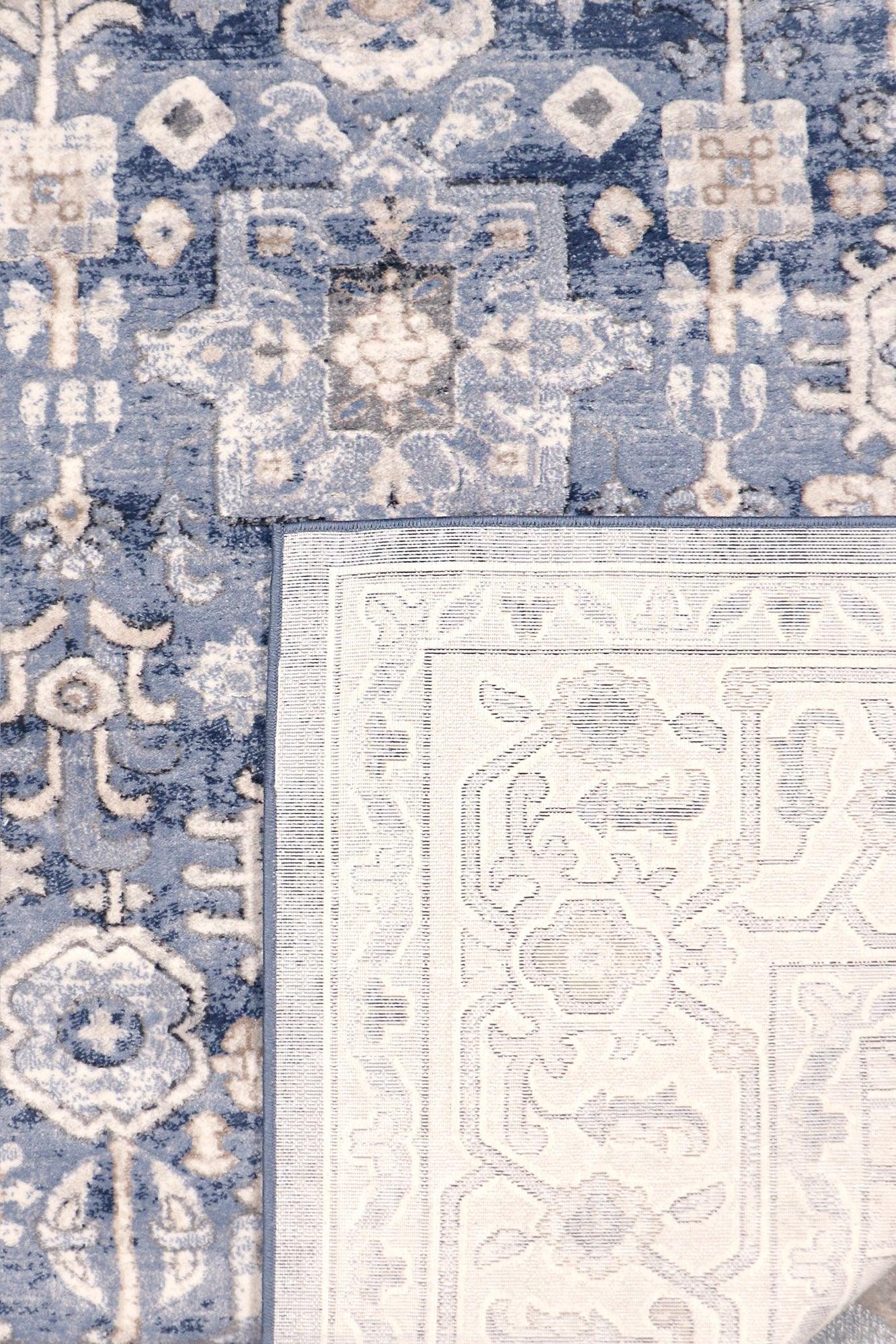 Close-up of a blue and white patterned rug with geometric designs.