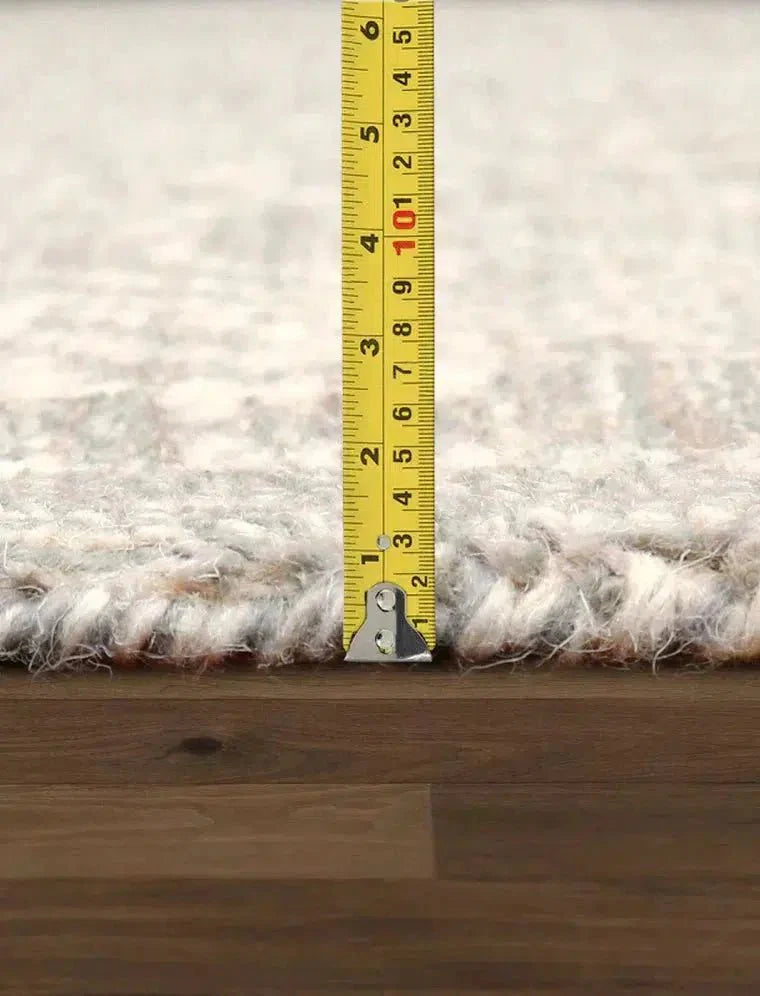 Rug on a wooden floor with a measuring tape indicating dimensions
