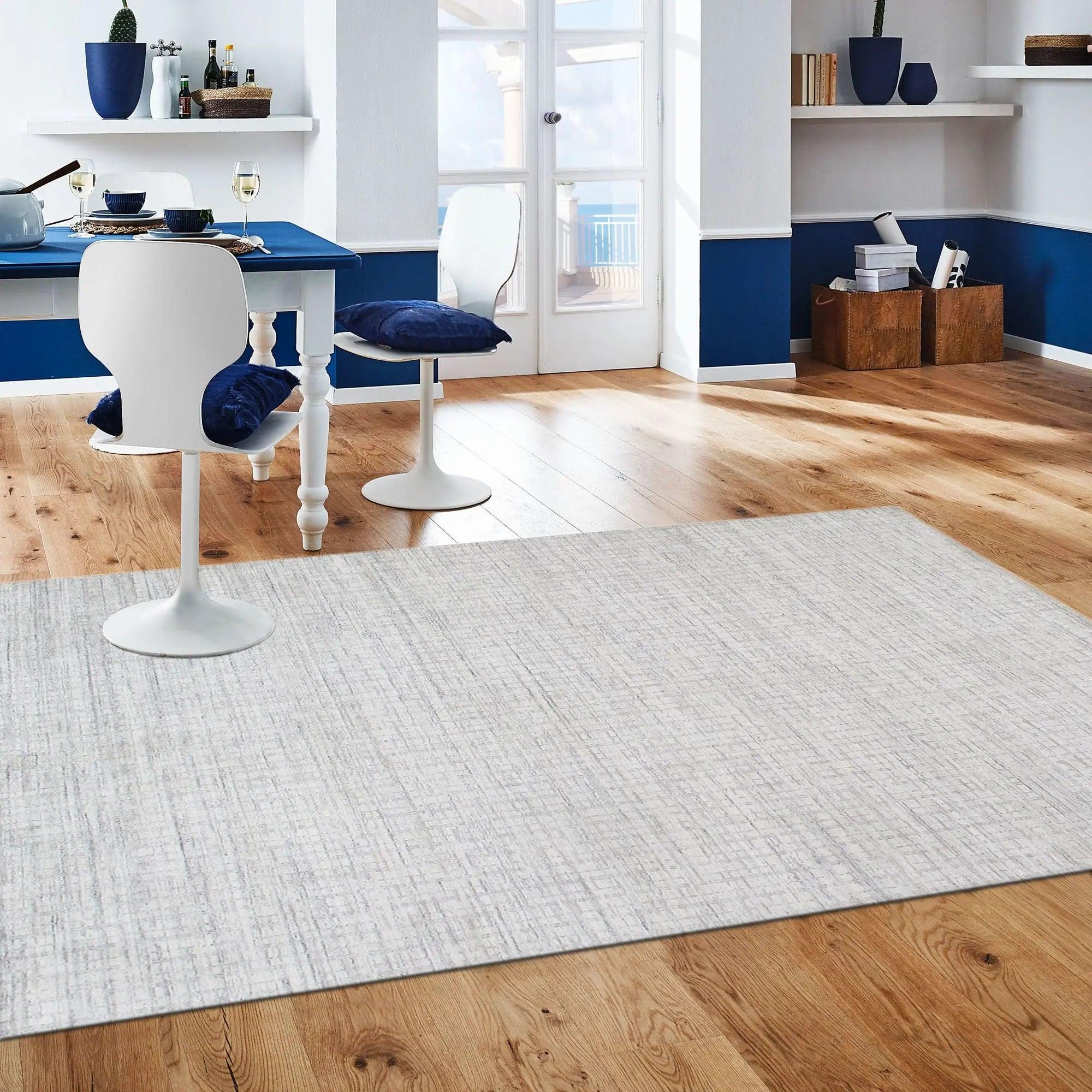 Modern room with blue walls, white furniture, and a gray rug on wooden flooring.
