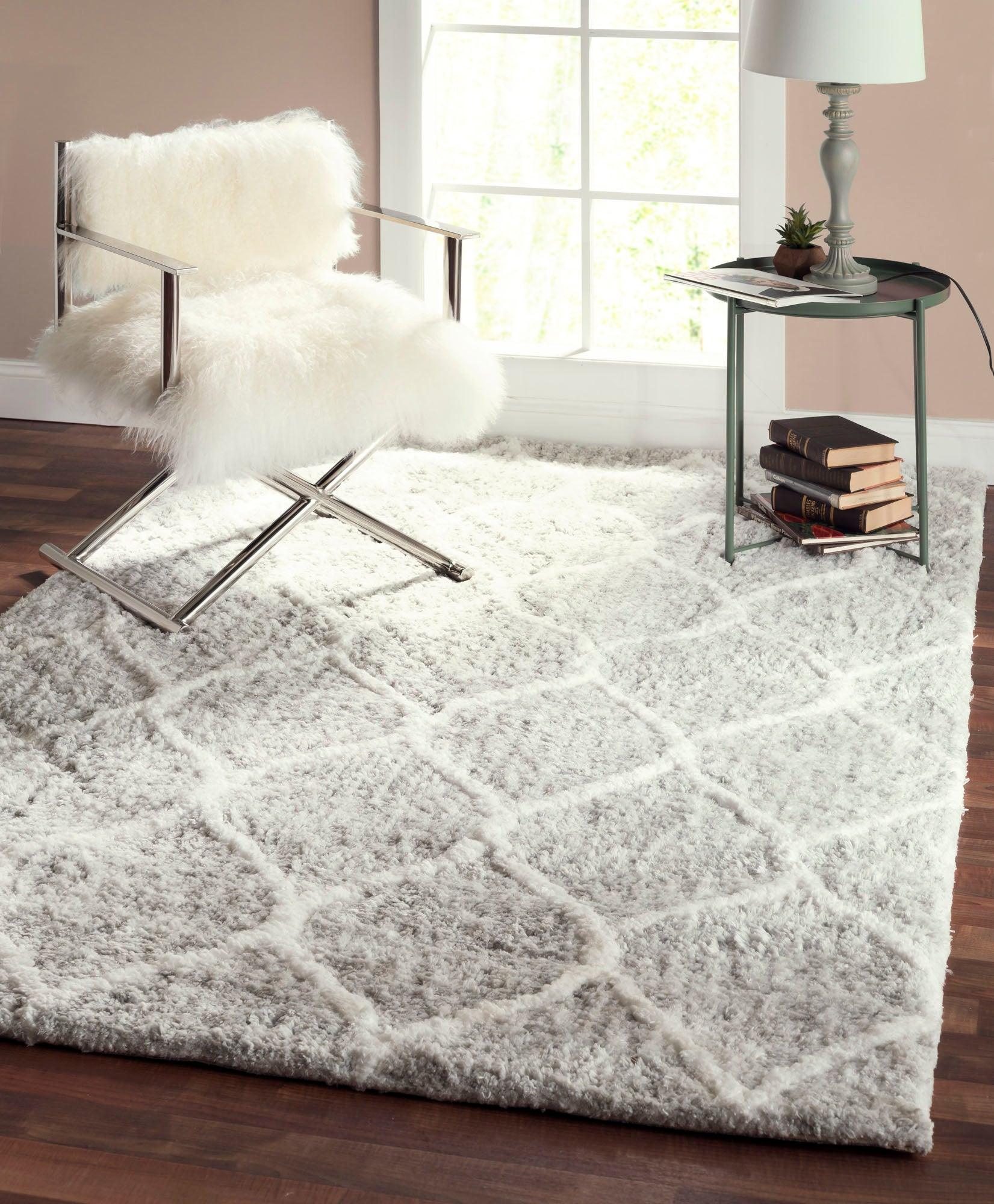 Living room with a textured gray rug, chair with white fur, and side table.