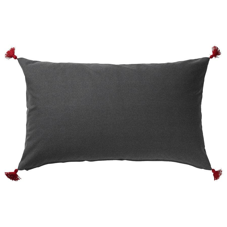Gray pillow with red tassels on a white background